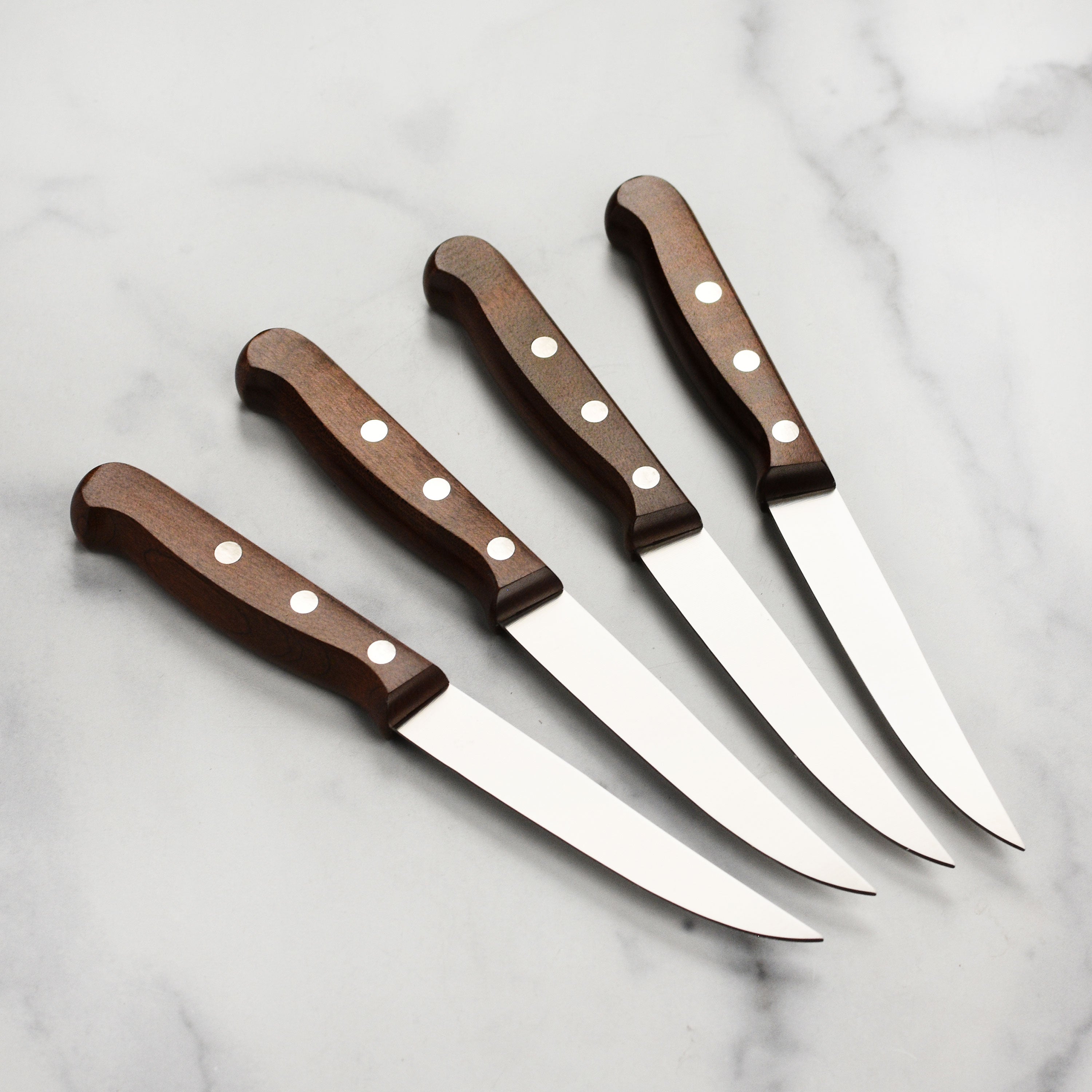 Set of Victorinox kitchen knives, including fine edge steak knives, on a wooden table