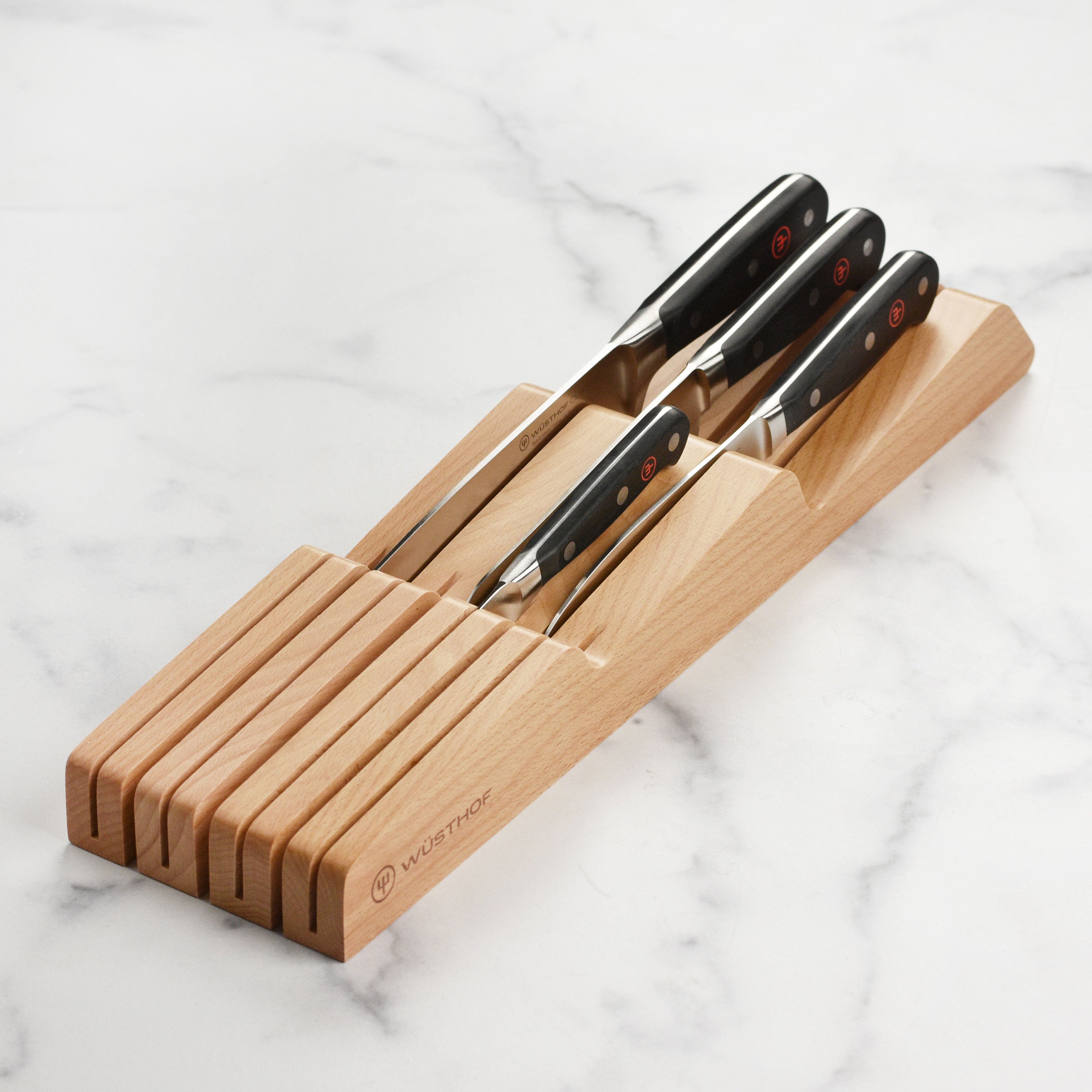 Close-up of premium forged chef knives from the Wusthof Classic set, showcasing the sharp blades