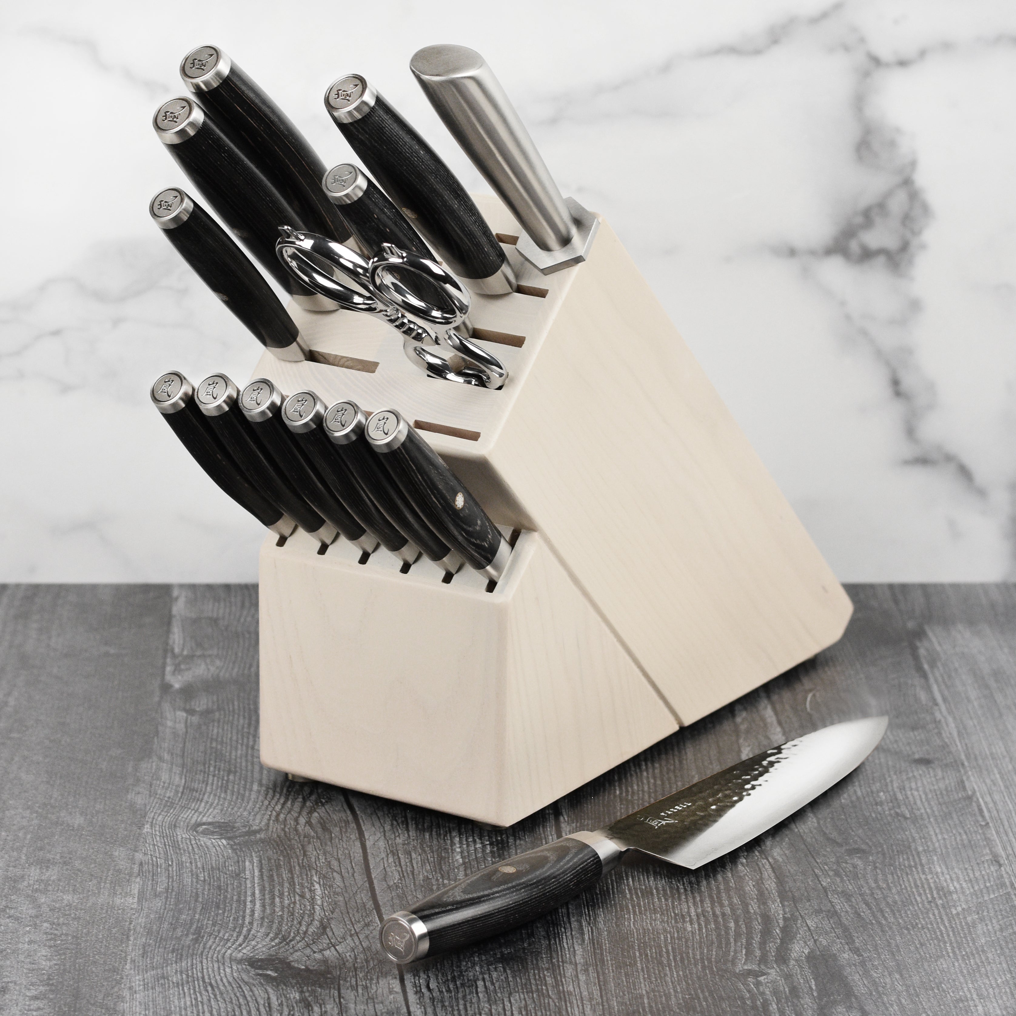 Japanese kitchen knife set displayed on a wooden countertop with a cutting board