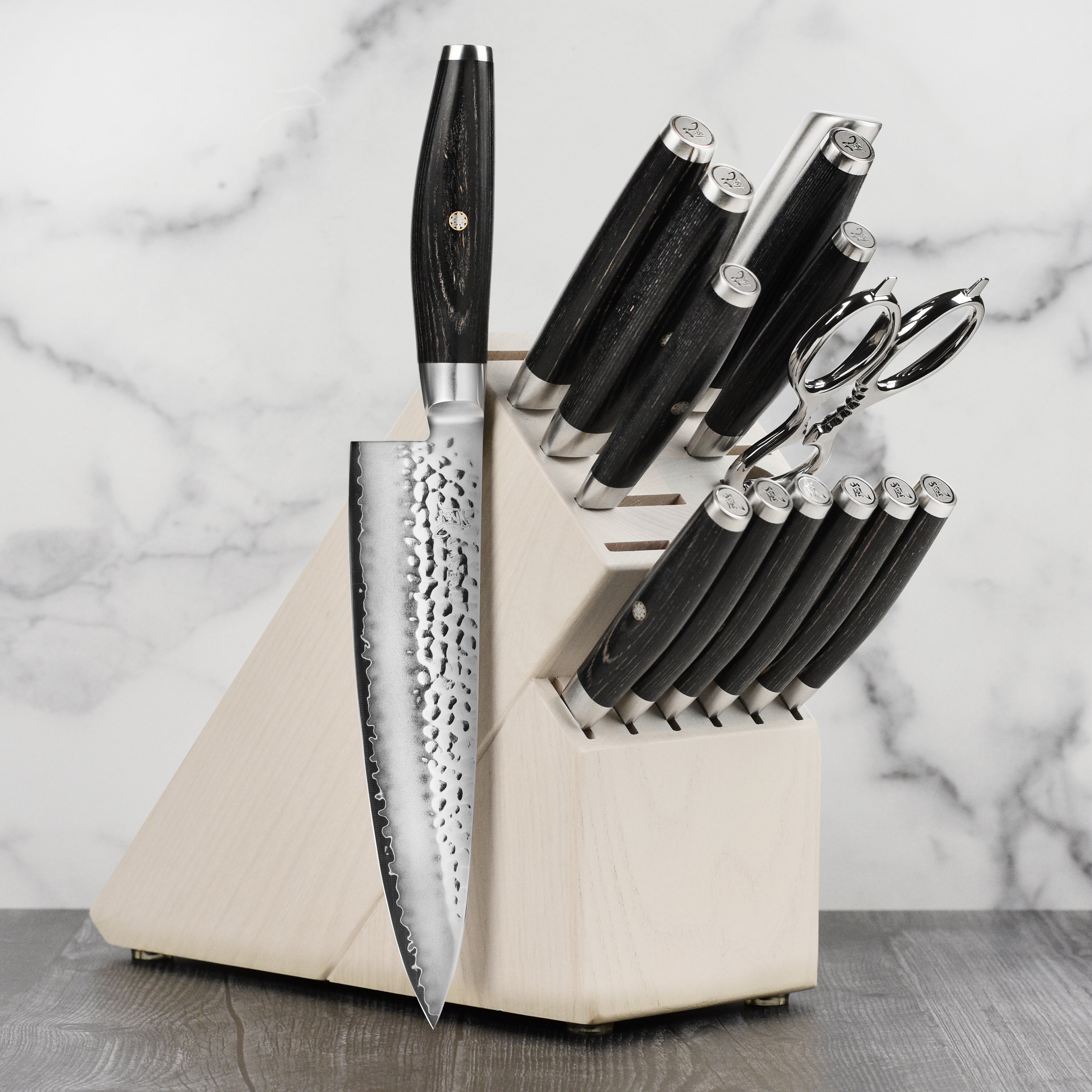 Close-up of hammered Japanese chef knives with black pakkawood handles