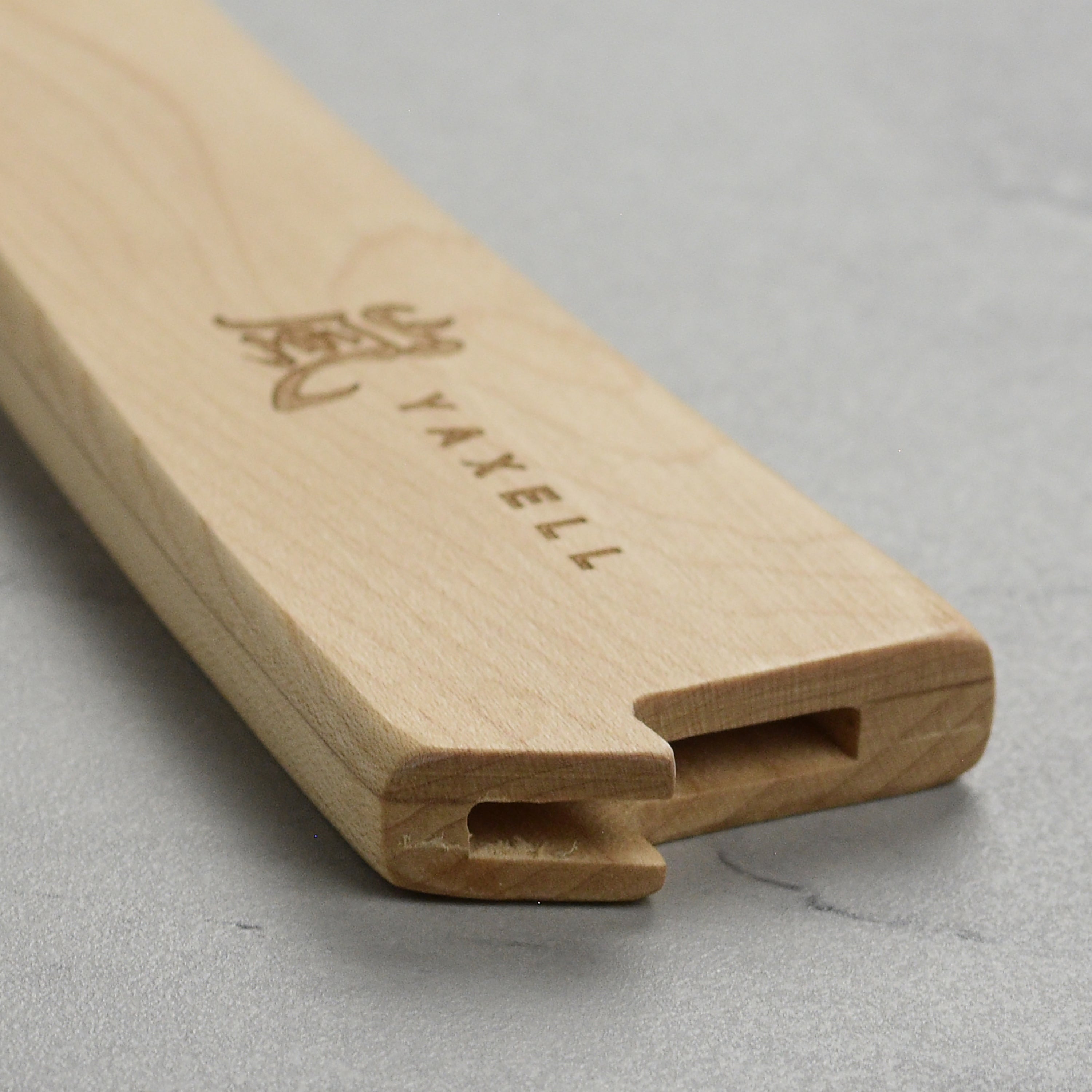 Yaxell knife sheath displayed on a wooden kitchen counter with other kitchen tools.