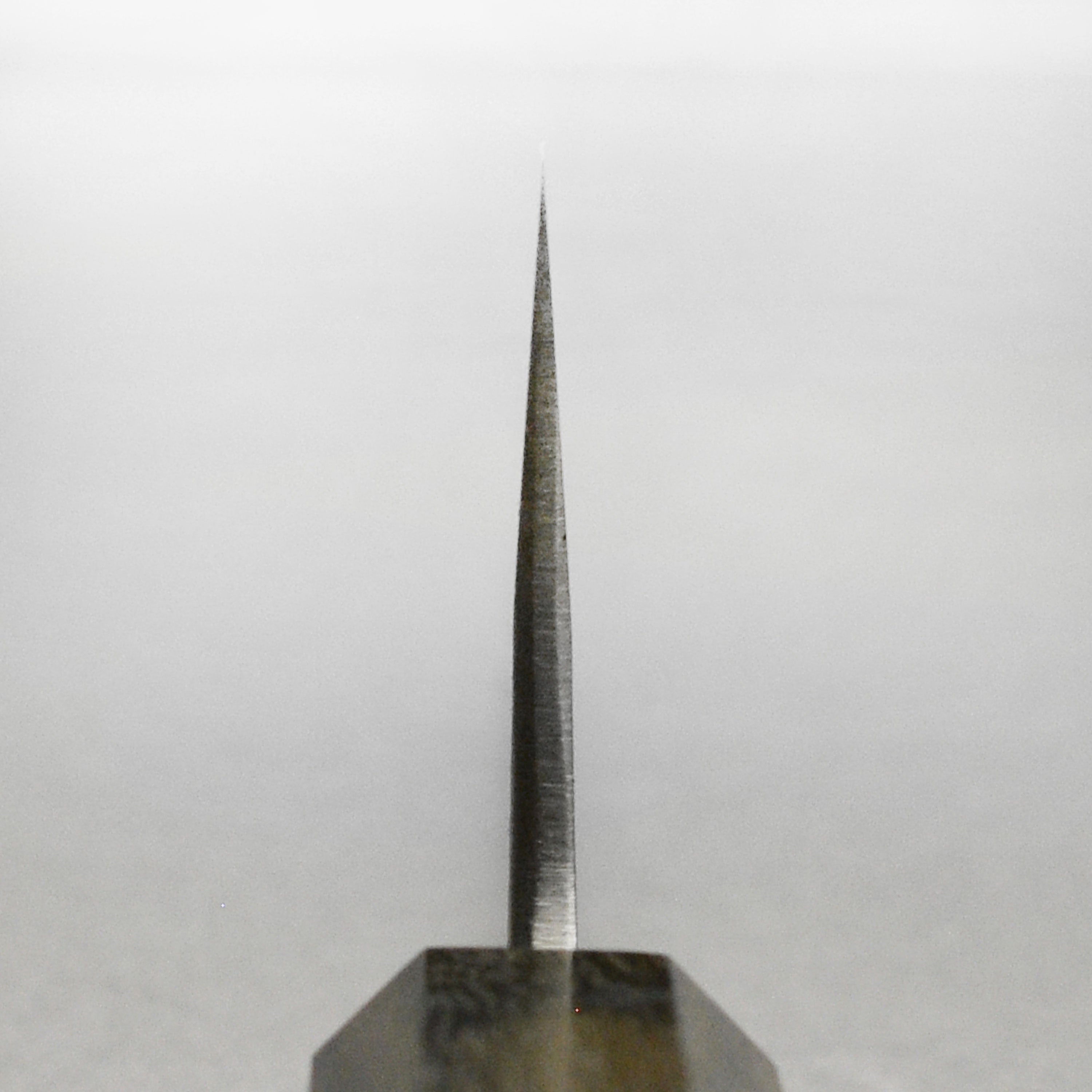 Close-up of the Yoshikane Nashiji 6.5-inch Santoku knifes blade showing its sharp edge.