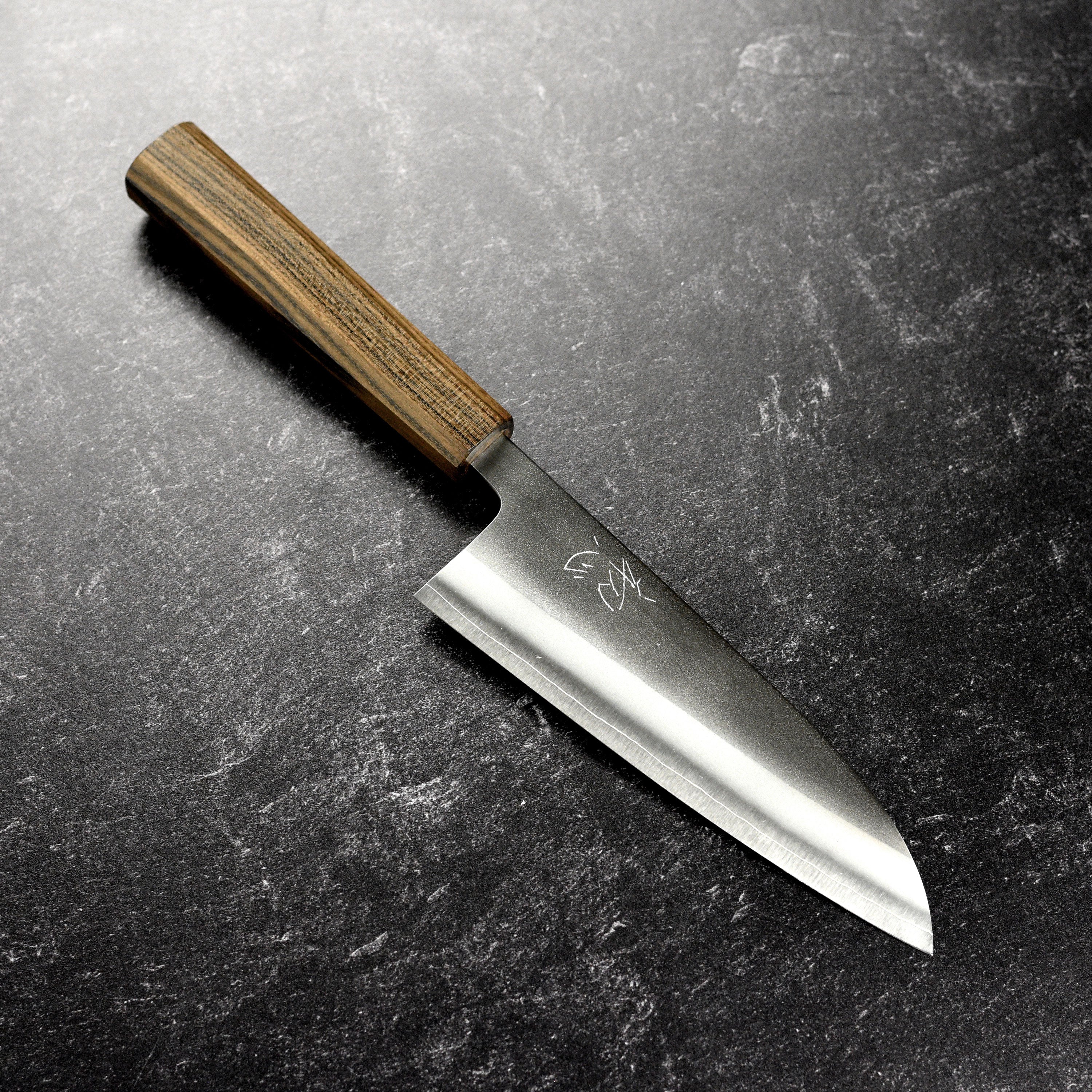 Close-up of the Yoshikane Nashiji 6.5-inch Santoku knife's blade showing its sharp edge.