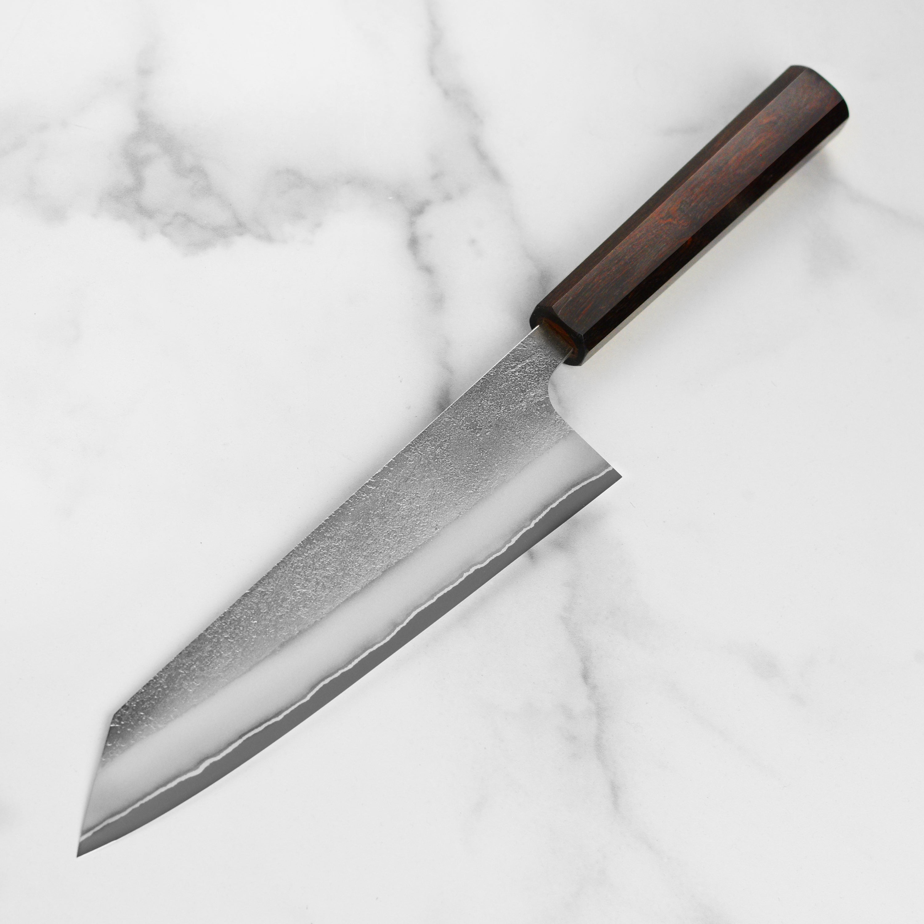 Professional chef using the Yoshikane Shirogami Kiritsuke knife for slicing fish with precision.