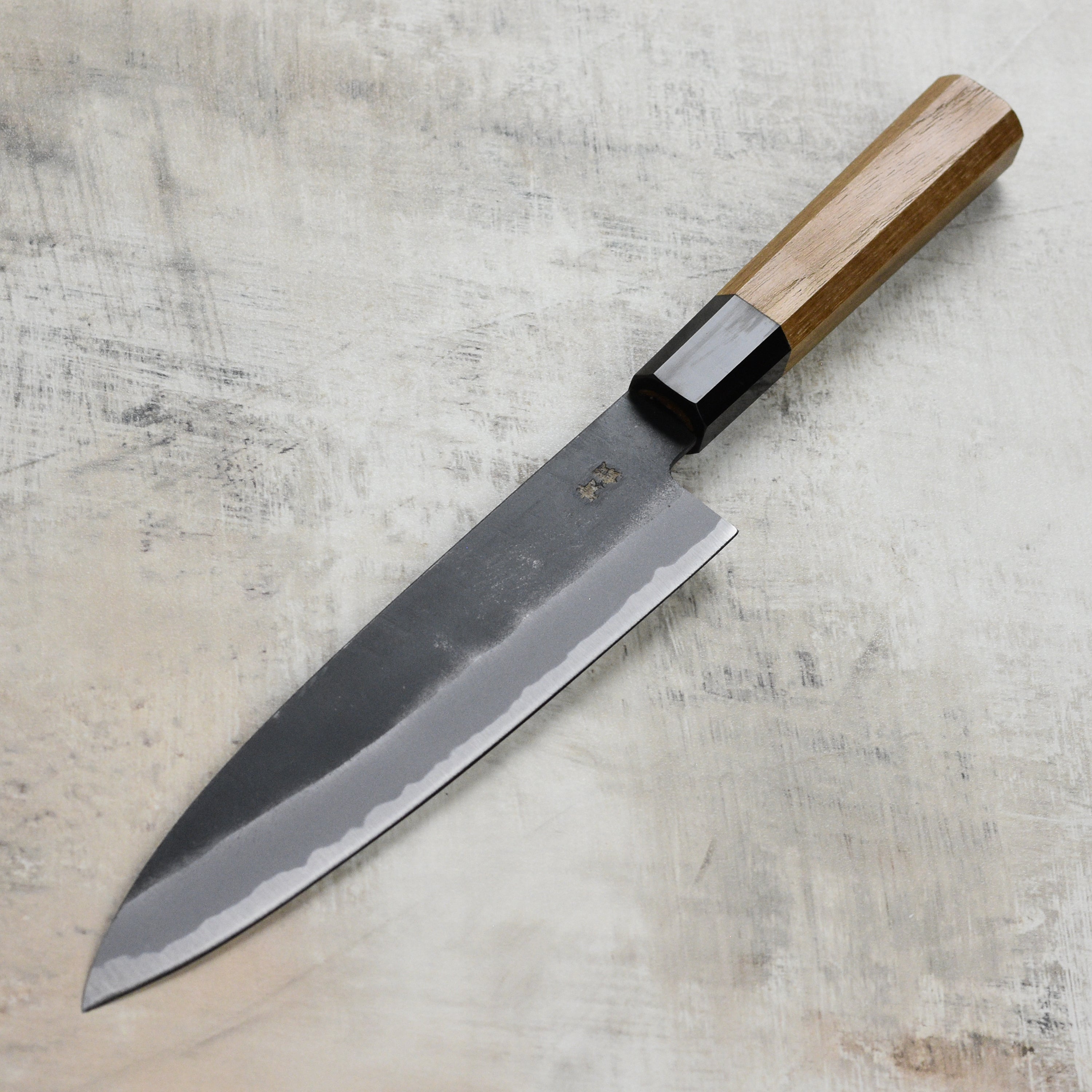 The Aogami steel gyuto knife in action, slicing fresh vegetables on a cutting board
