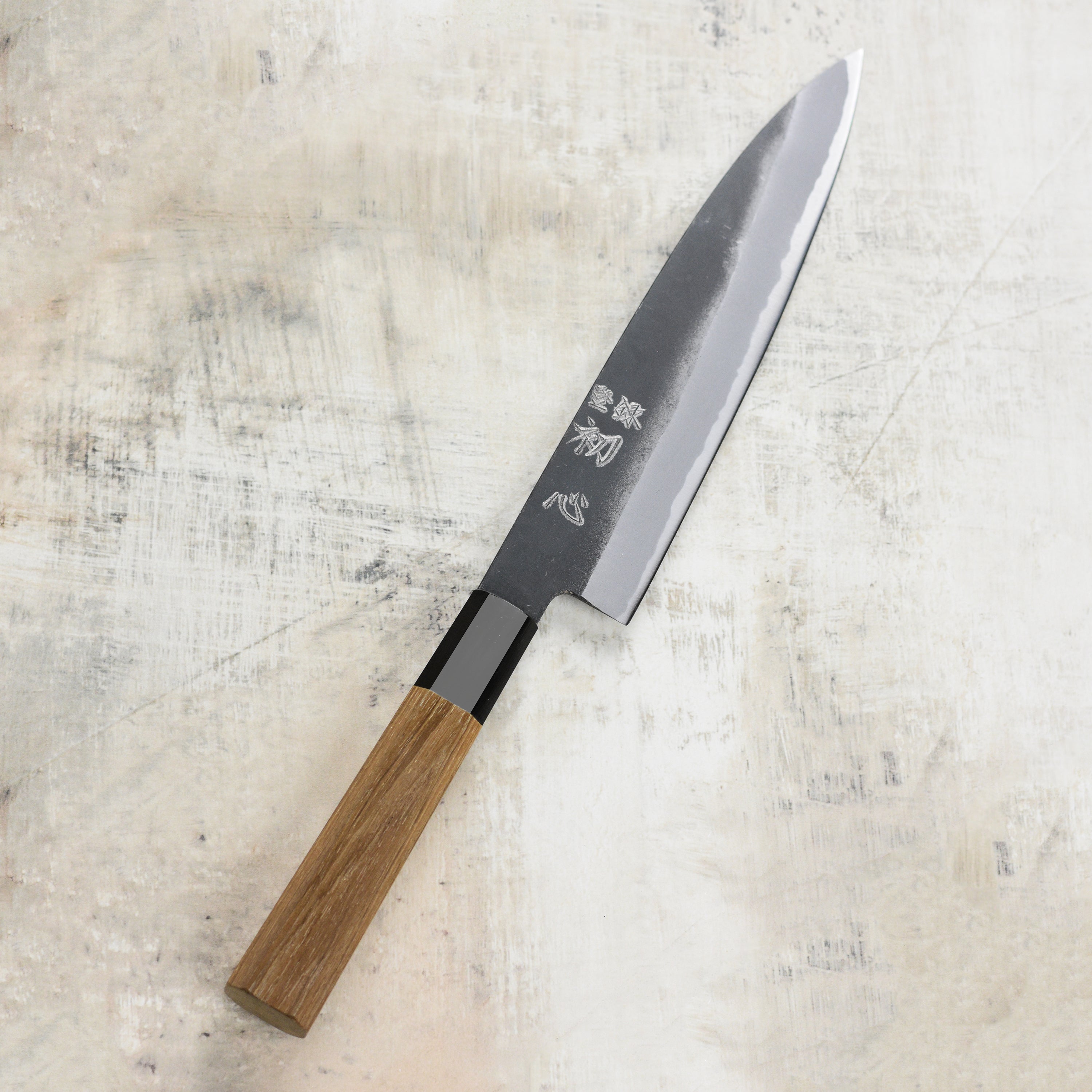Close-up of the blade of the Aogami steel gyuto knife highlighting the kurouchi finish