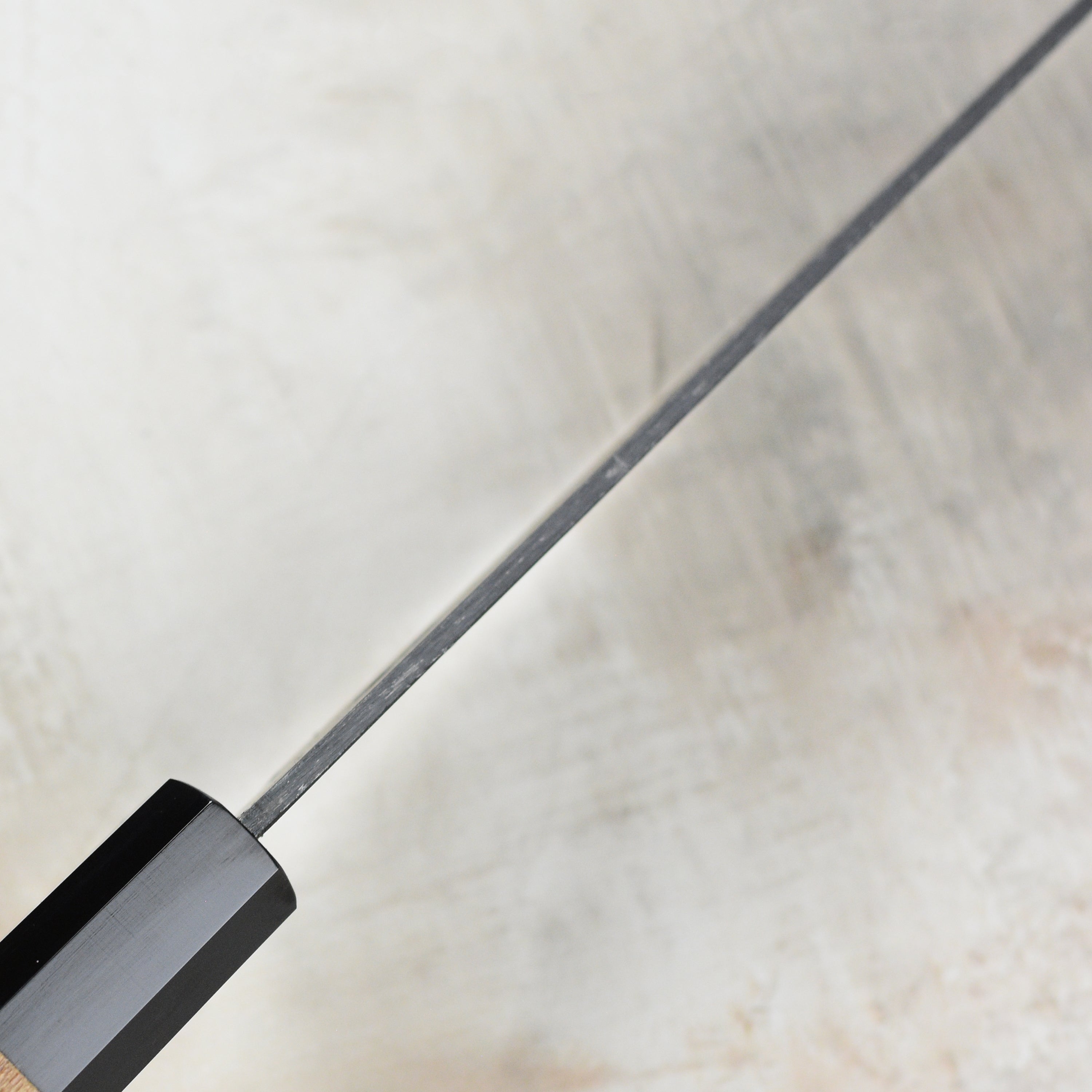 The Aogami steel gyuto knife in action, slicing fresh vegetables on a cutting board