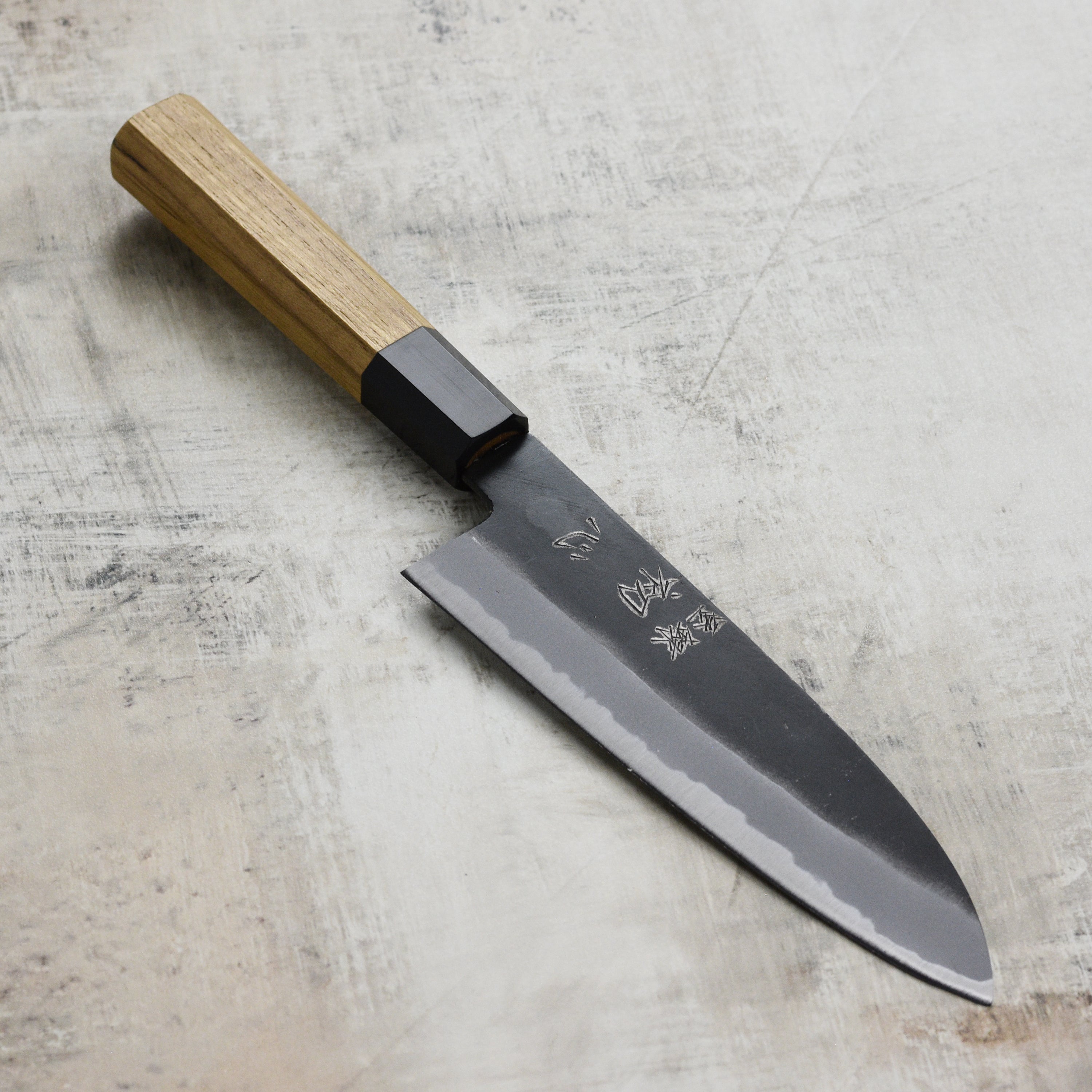 Japanese Santoku knife with rustic Kurouchi finish, ideal for home chefs