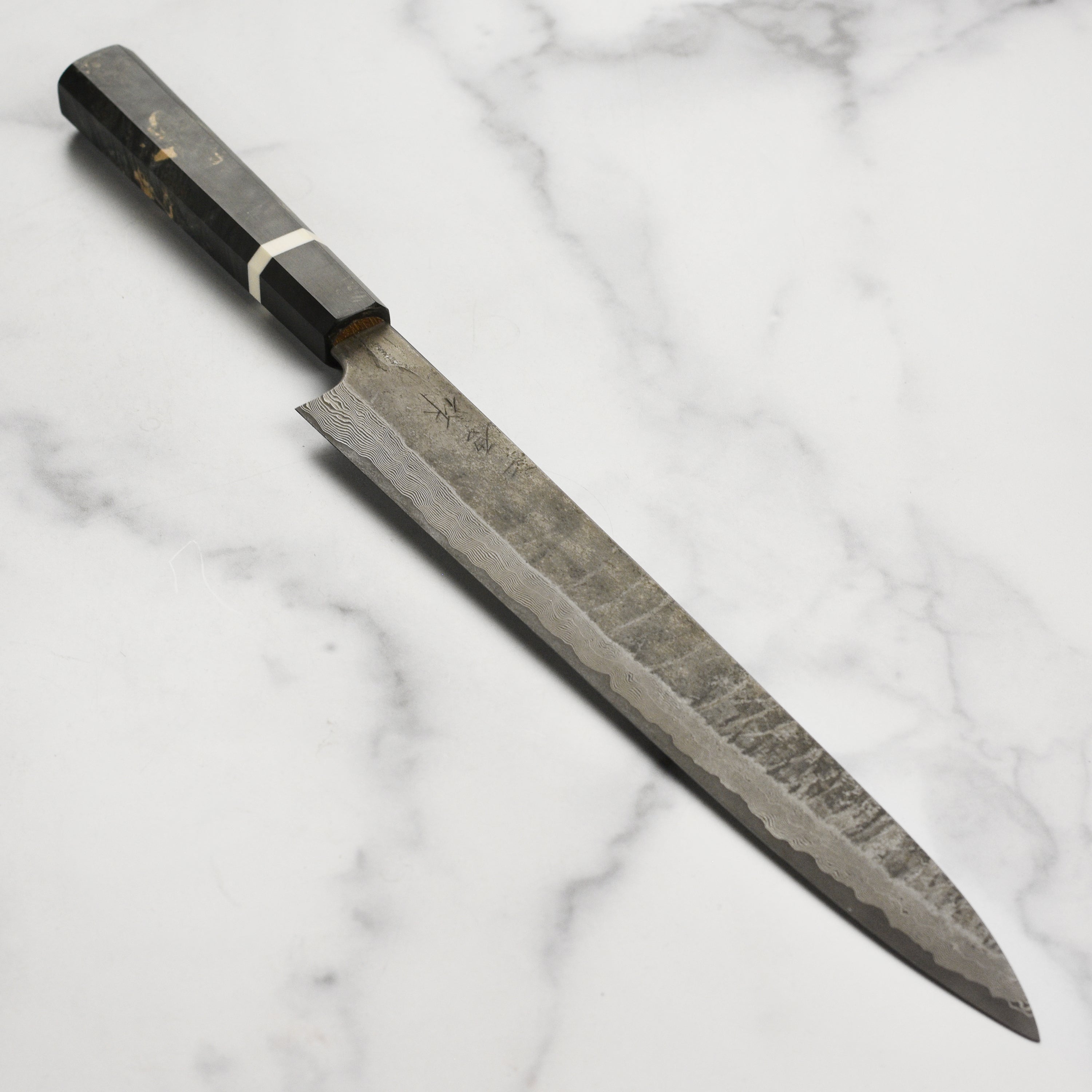 Close-up of the Premium Nigara Ginsan Damascus Sujihiki Knife showcasing its blade and handle.