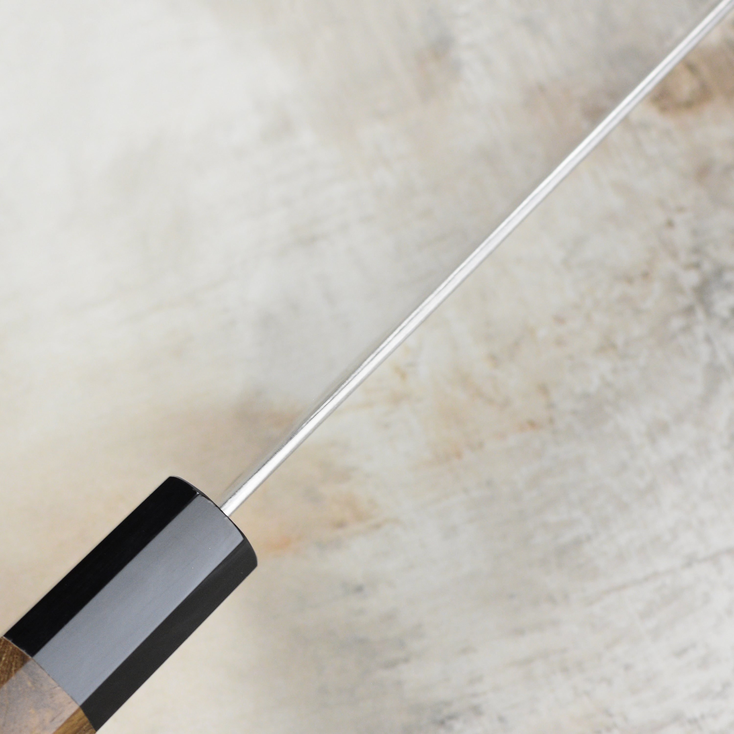 Close-up of the Ginsan steel blade showcasing craftsmanship and damascus pattern