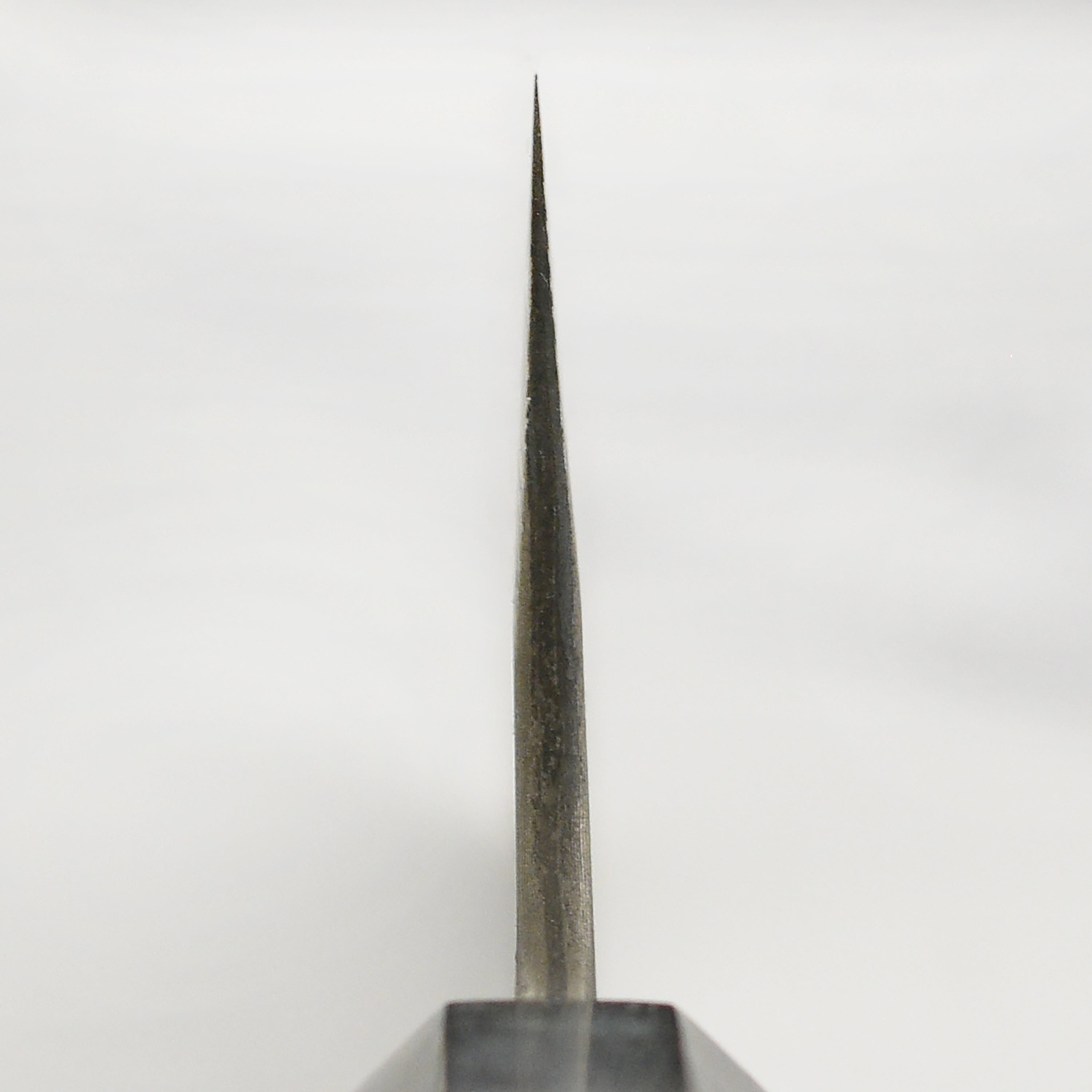Elegant handle and blade of the 8.25-inch Nigara Gyuto knife in a professional kitchen setting