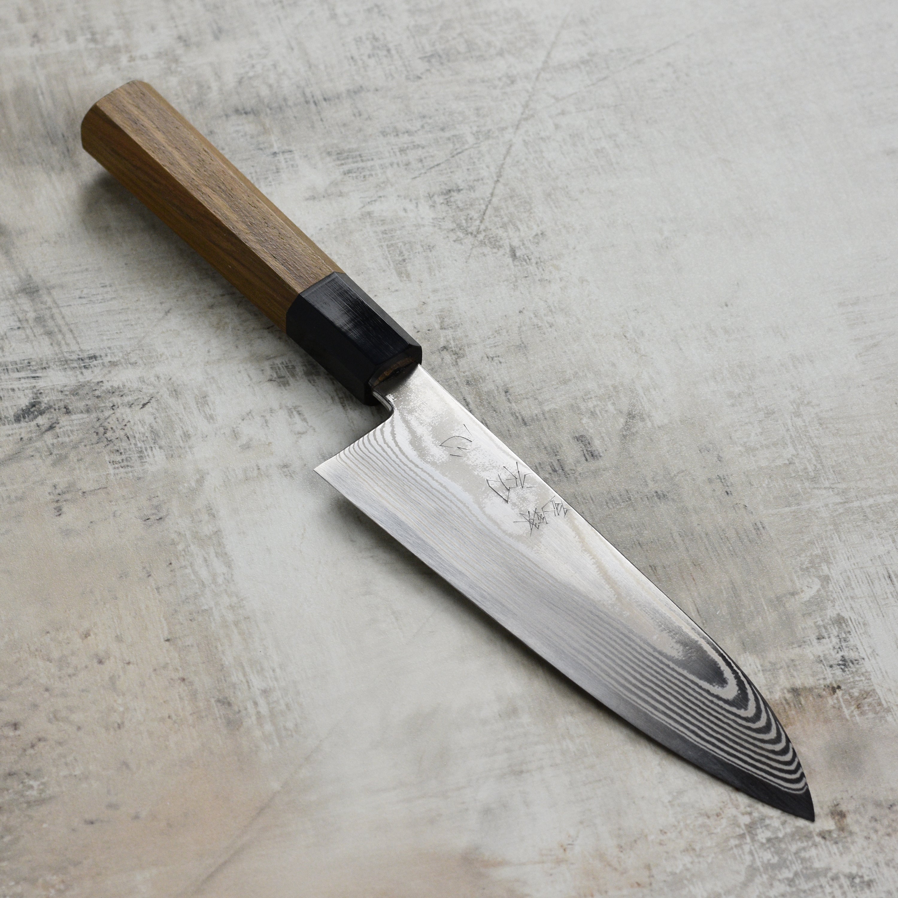 Front view of the handmade Japanese santoku knife with damascus steel pattern