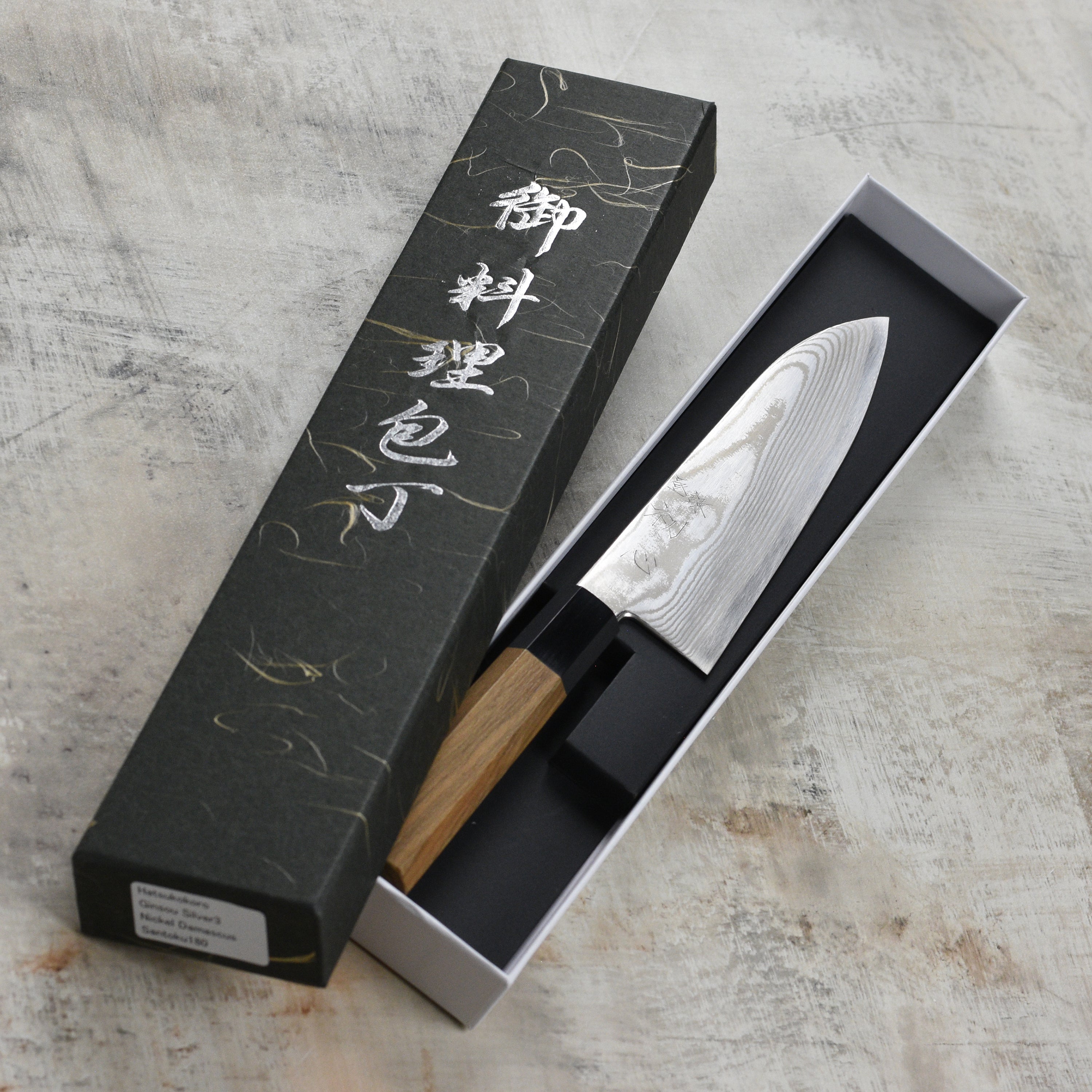 Front view of the handmade Japanese santoku knife with damascus steel pattern