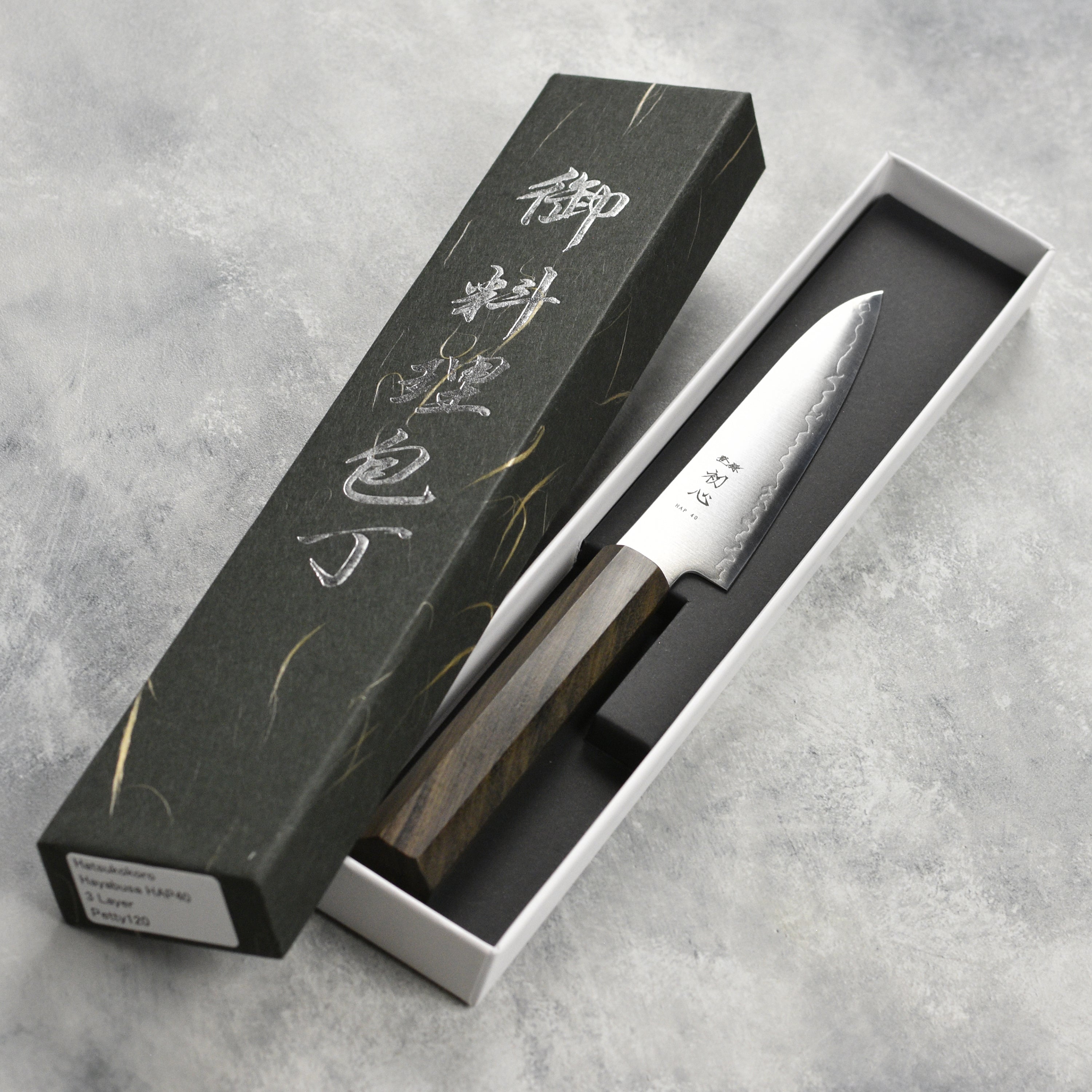 The Hatsukokoro Hayabusa HAP40 petty knife next to a selection of fresh ingredients, showcasing its practicality for home cooks.