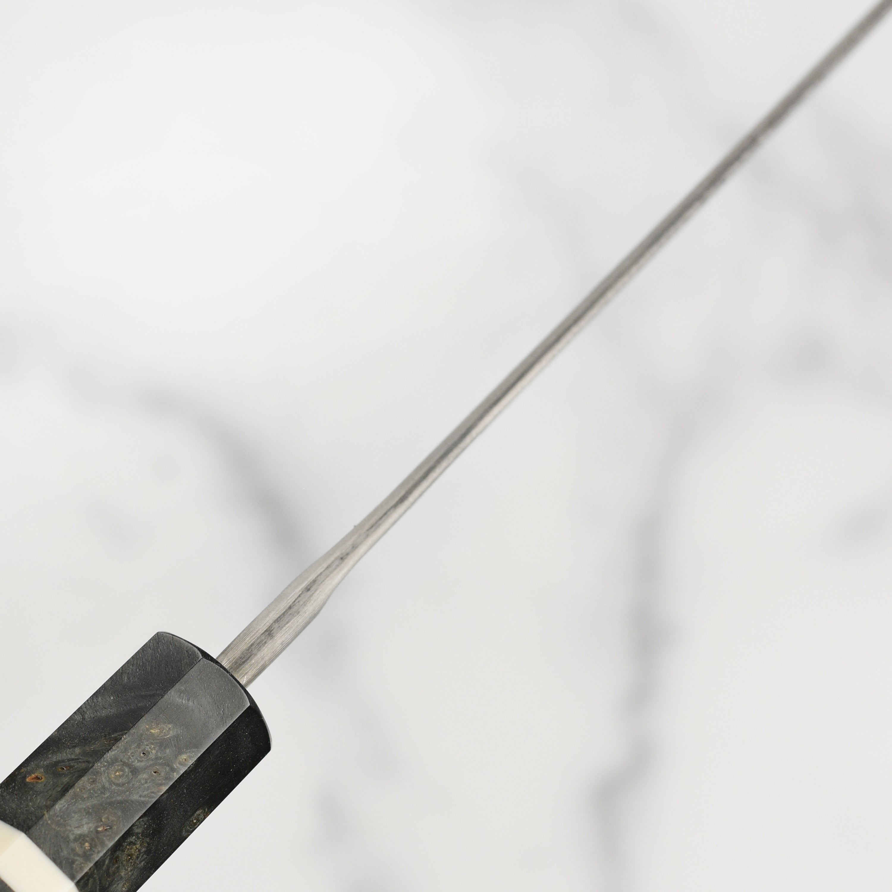 The Ginsan Kiritsuke knife displayed on a wooden cutting board with fresh ingredients.