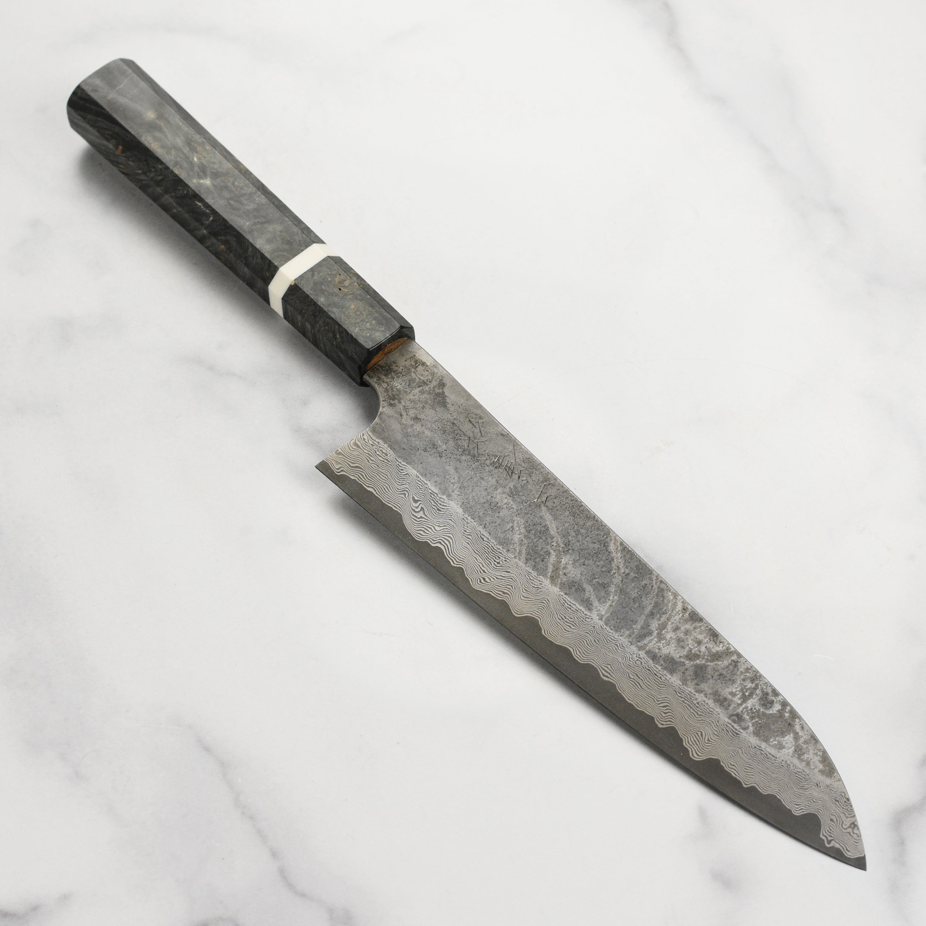 Close-up of Nigara Damascus gyuto knife blade highlighting Damascus steel pattern