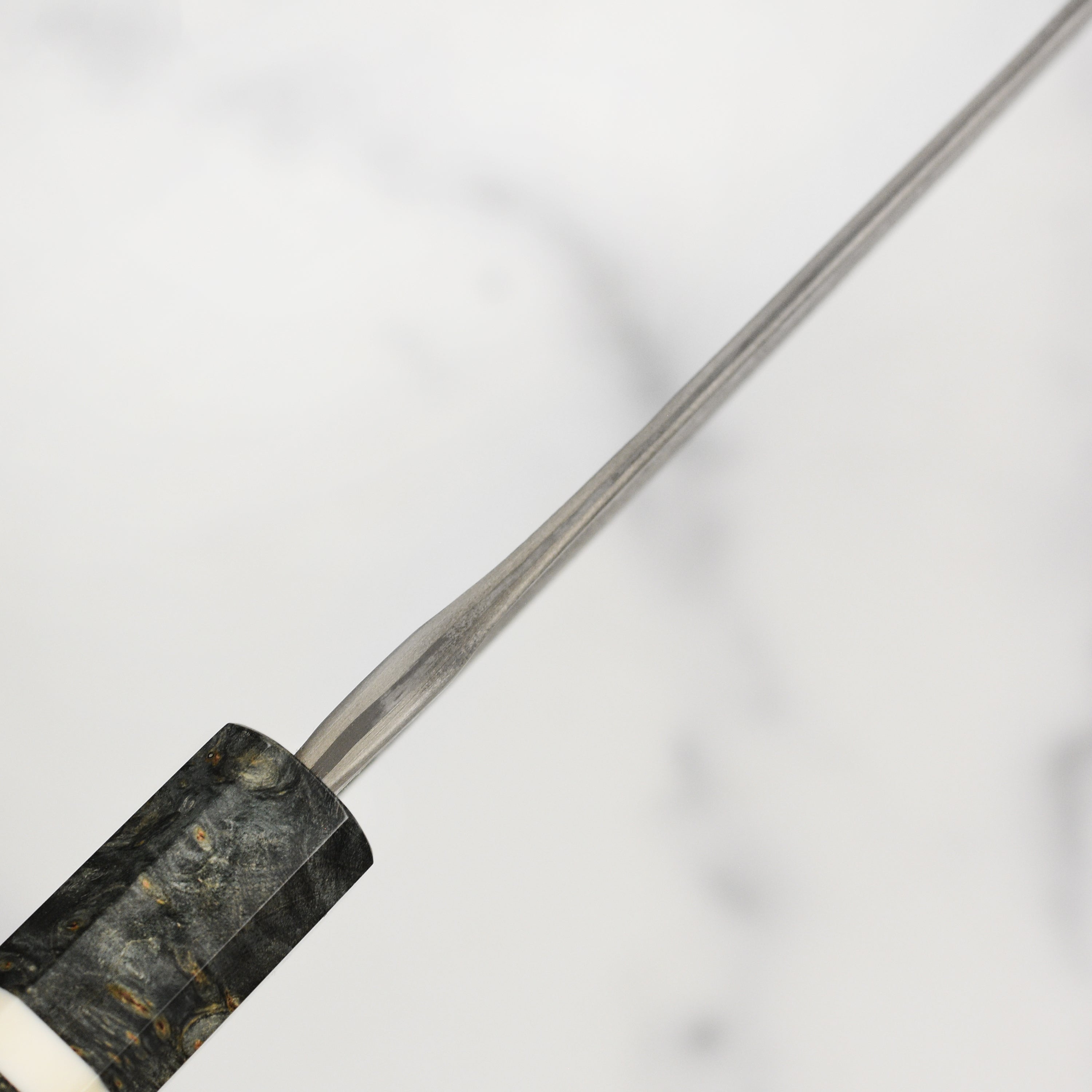 Elegant handle and blade of the 8.25-inch Nigara Gyuto knife in a professional kitchen setting