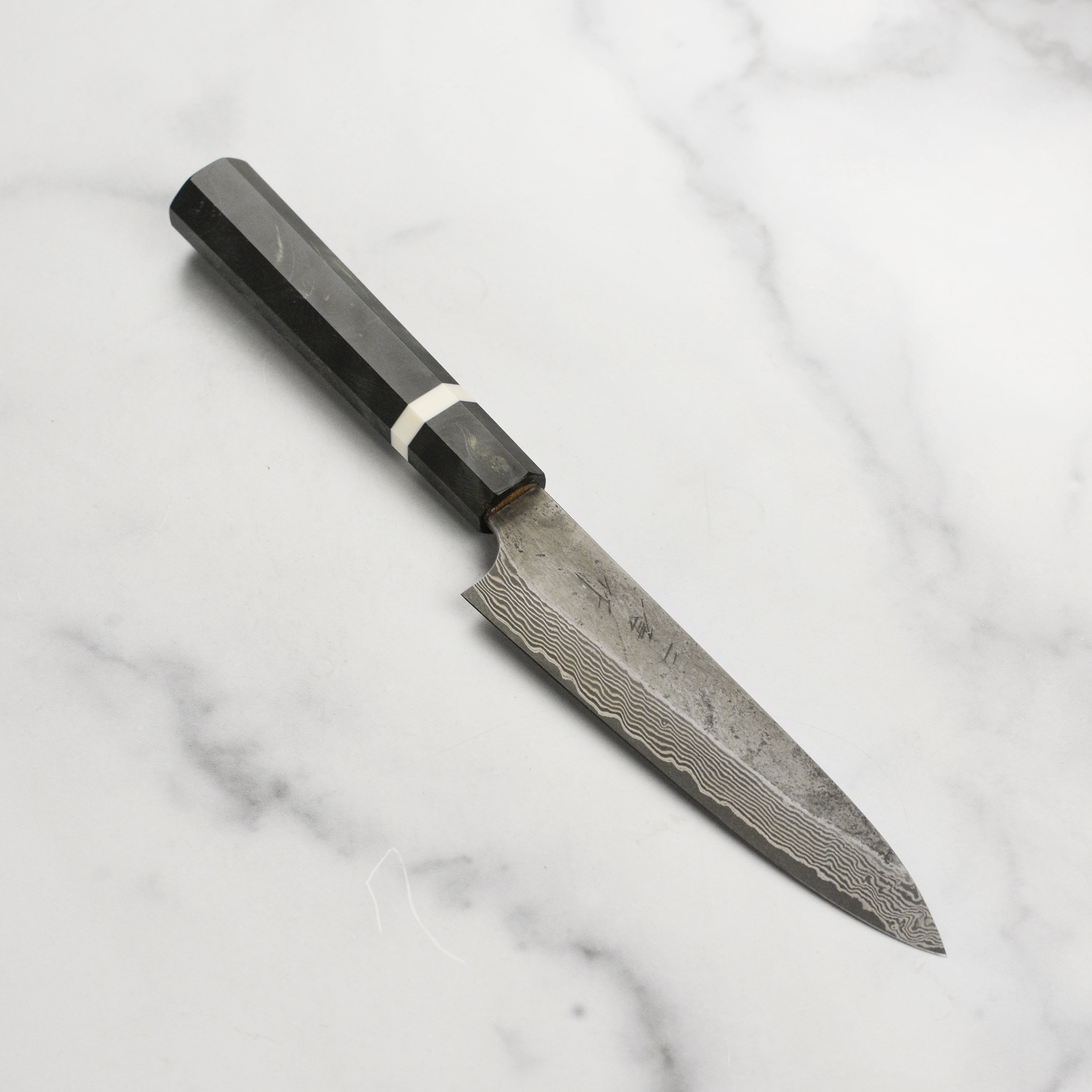 Close-up of the Premium Nigara Ginsan Damascus Petty Knife showcasing its sharp blade and ergonomic handle.