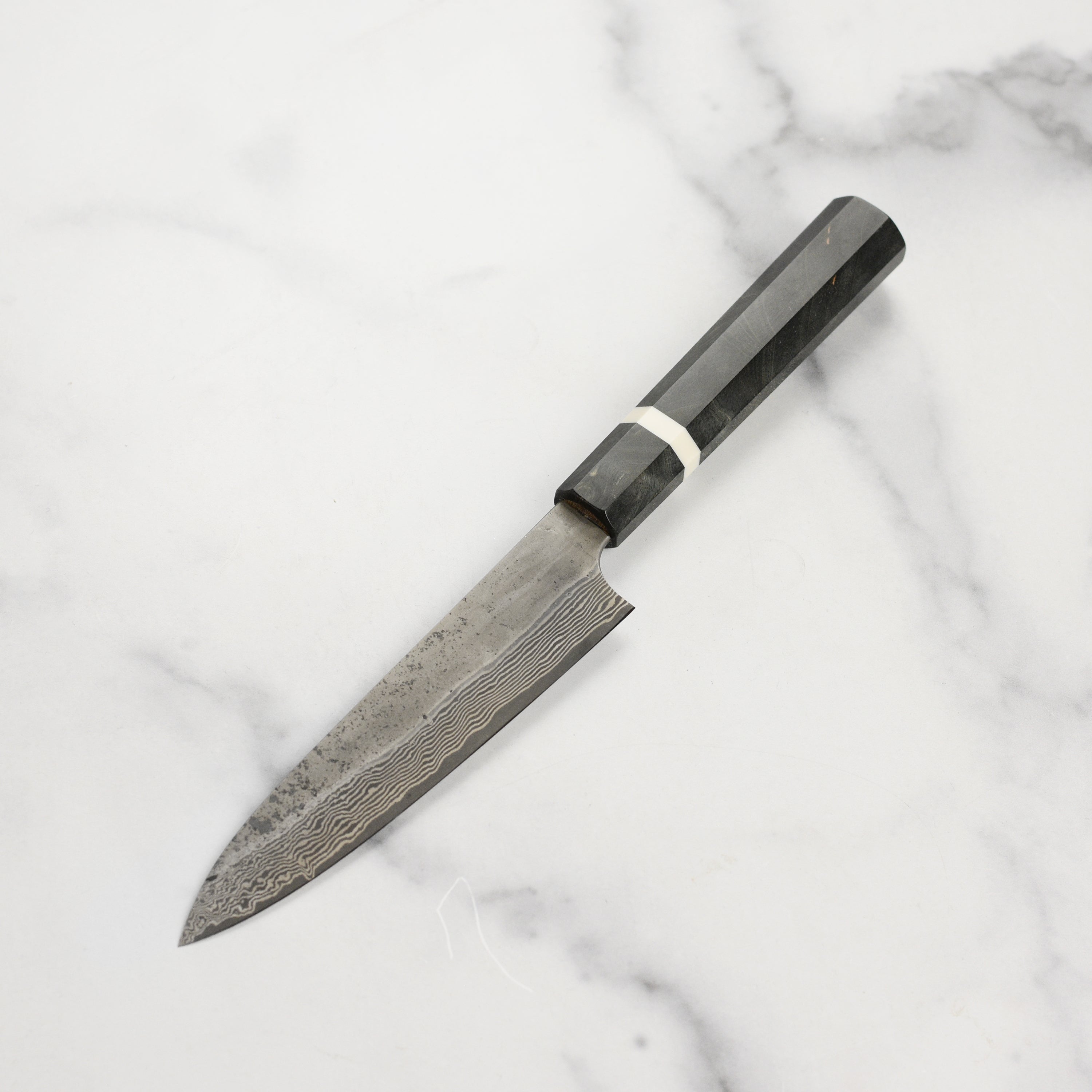 Close-up of the Premium Nigara Ginsan Damascus Petty Knife showcasing its sharp blade and ergonomic handle.