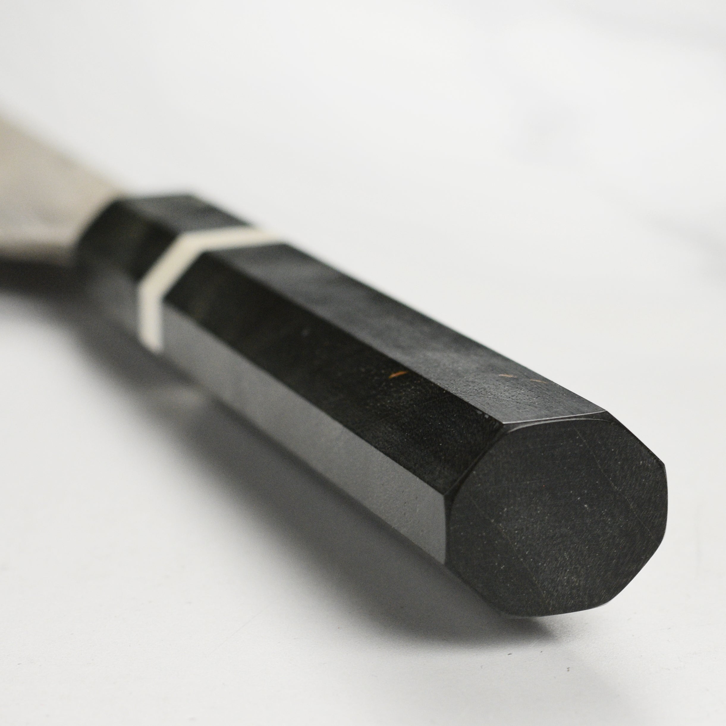 The Premium Nigara Ginsan Damascus Petty Knife in action, slicing fresh vegetables on a wooden cutting board.