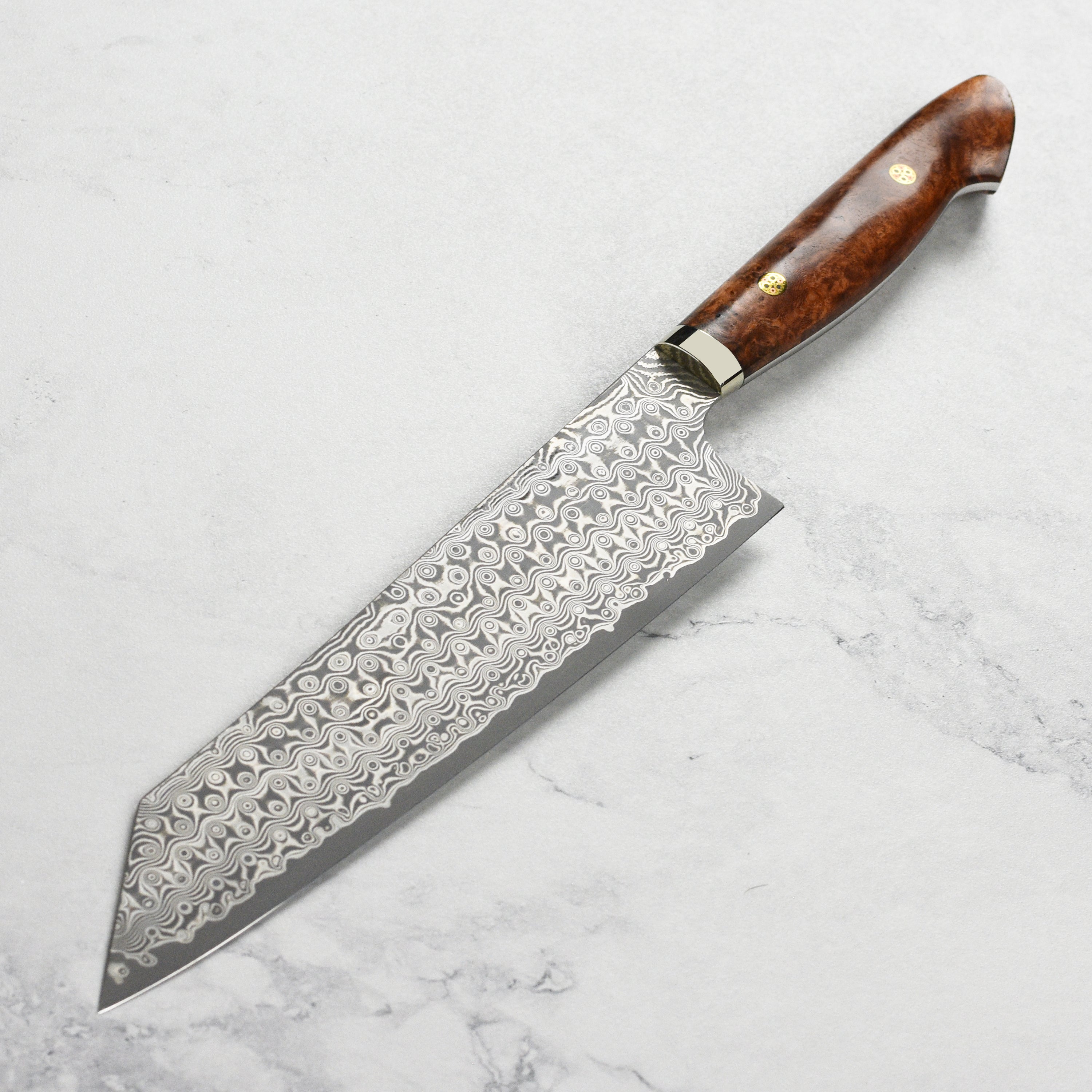 Kitchen setting with Nigara Anmon SG2 Damascus Kiritsuke knife slicing vegetables smoothly