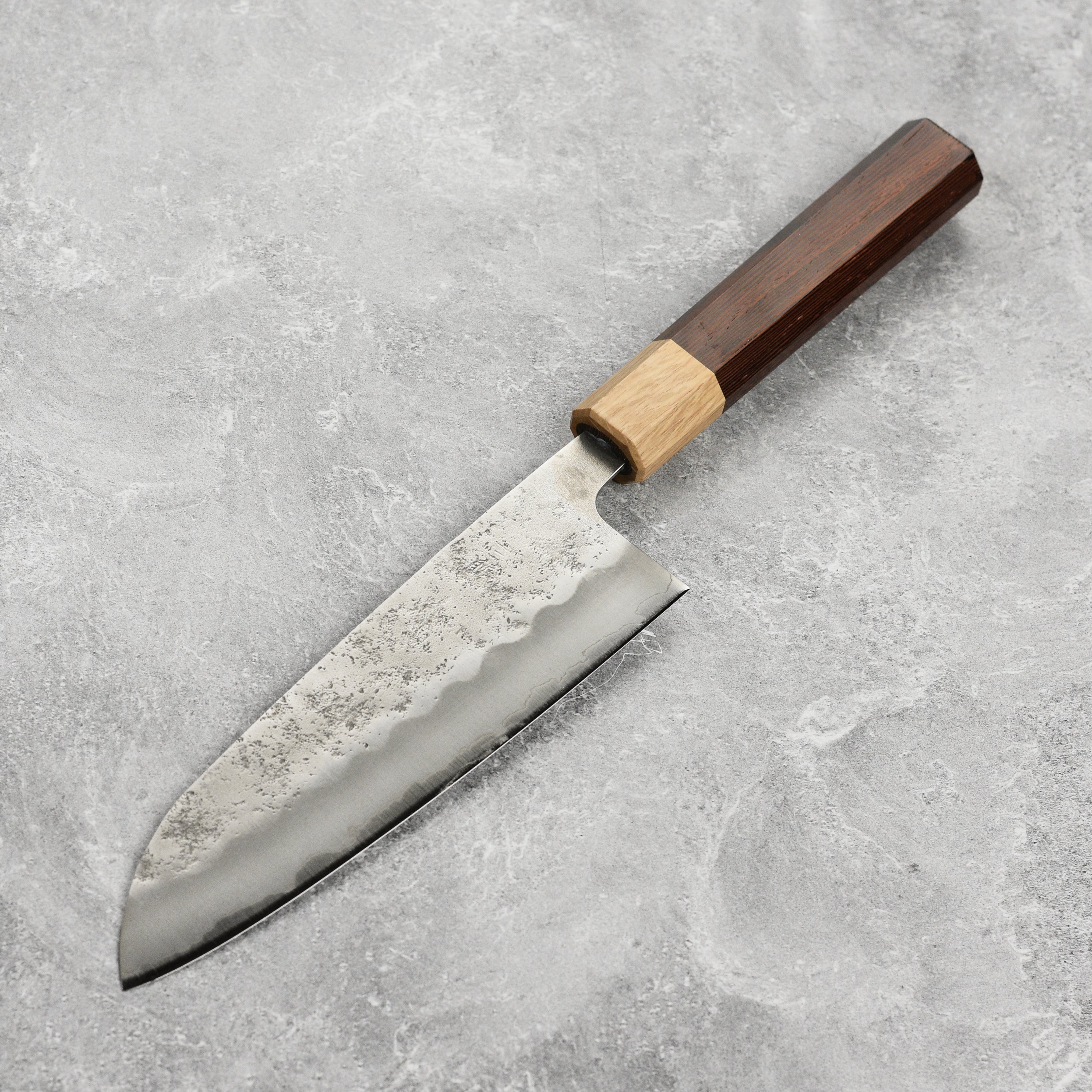 Close-up of the Enso Ginsan Santoku knife cutting through fresh herbs, demonstrating precision cutting.