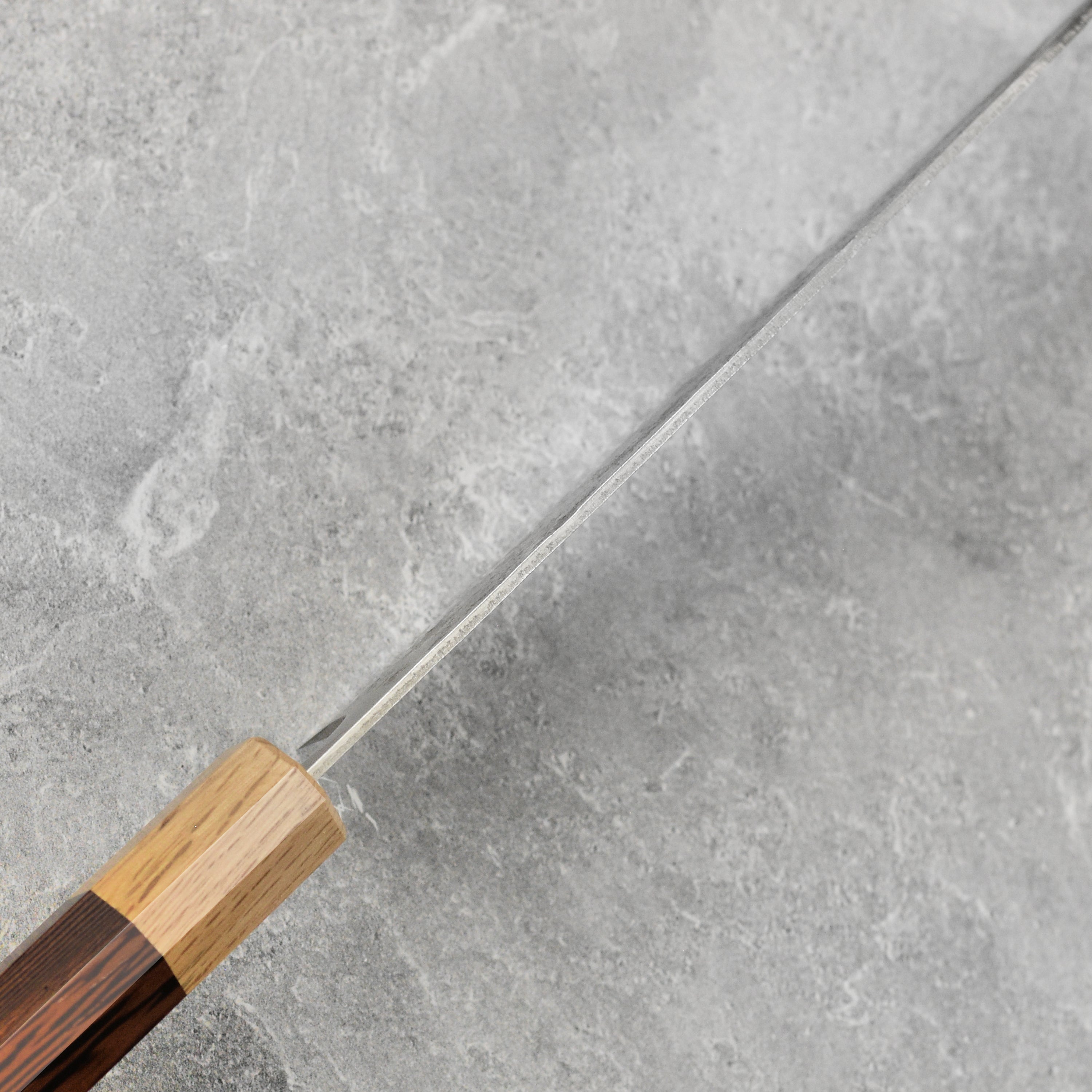 Enso Ginsan 6.5" Santoku knife resting on a vibrant array of ingredients, highlighting its versatility.
