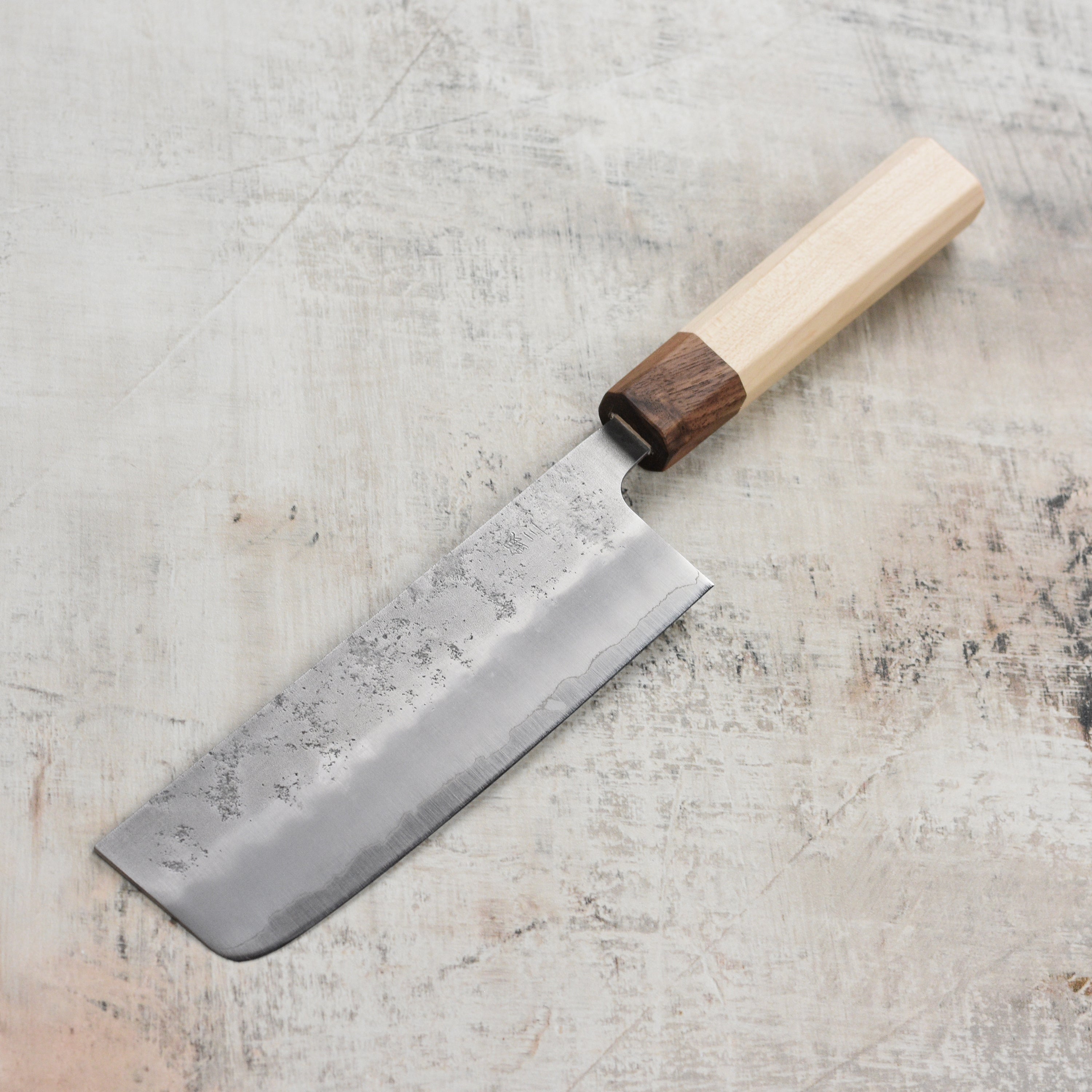 Close-up of Ginsan steel nakiri knifes sharp edge and ergonomic handle