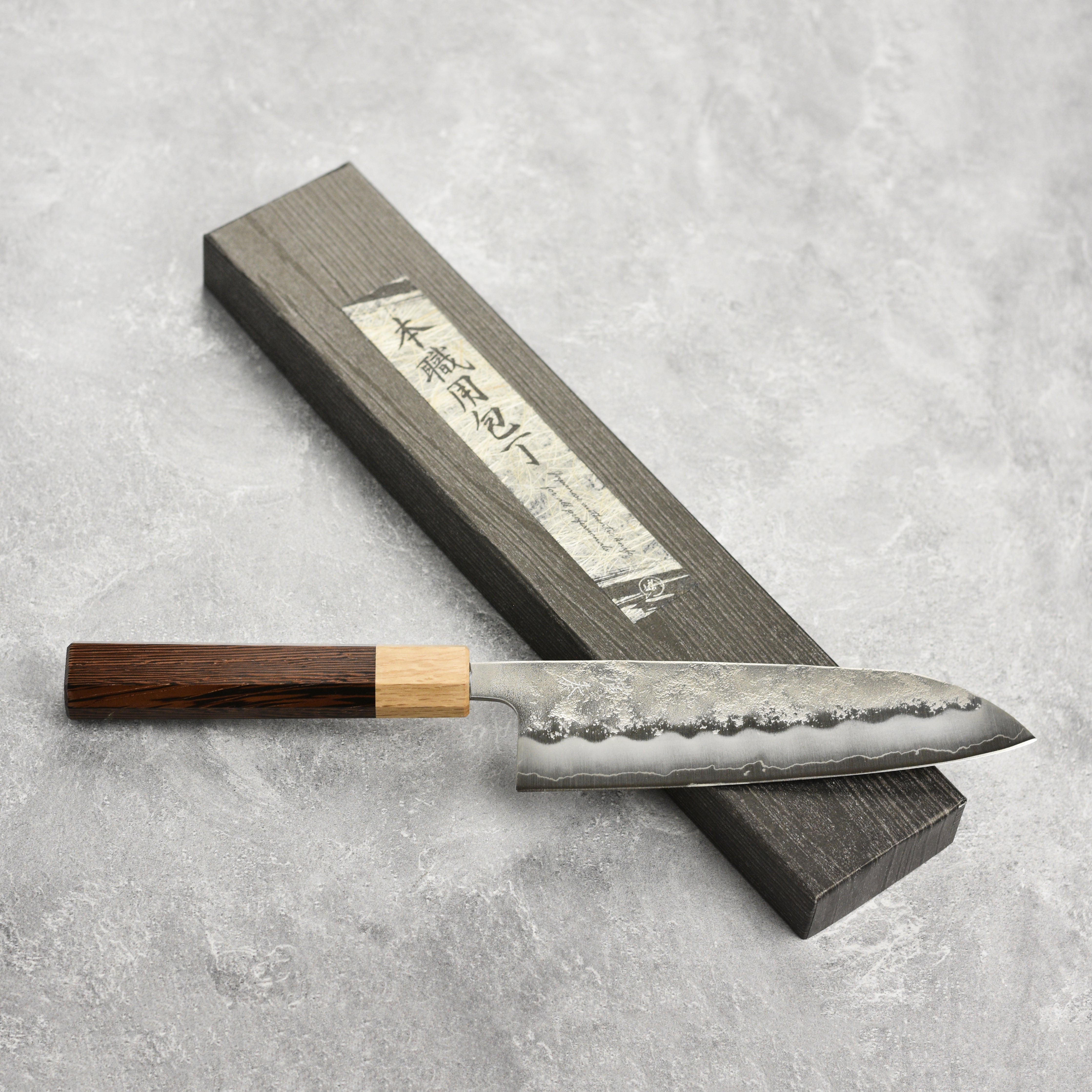 Enso Ginsan 6.5" Santoku knife resting on a vibrant array of ingredients, highlighting its versatility.