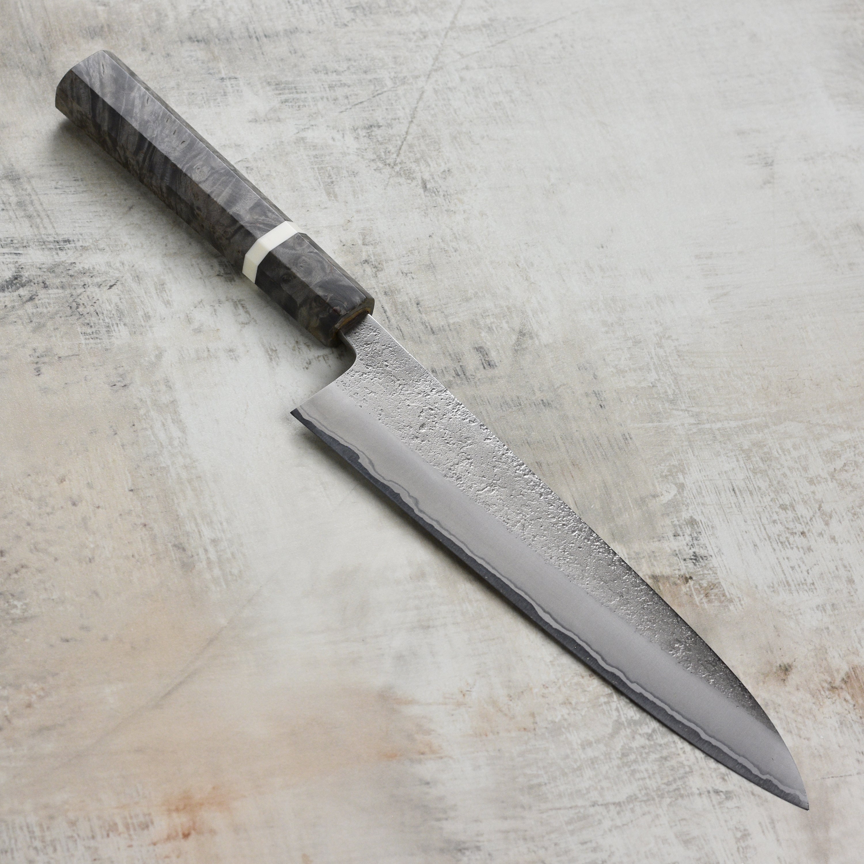 Close-up of the Yoshikane Shirogami Gyuto Knife blade highlighting its sharpness and stainless steel finish.