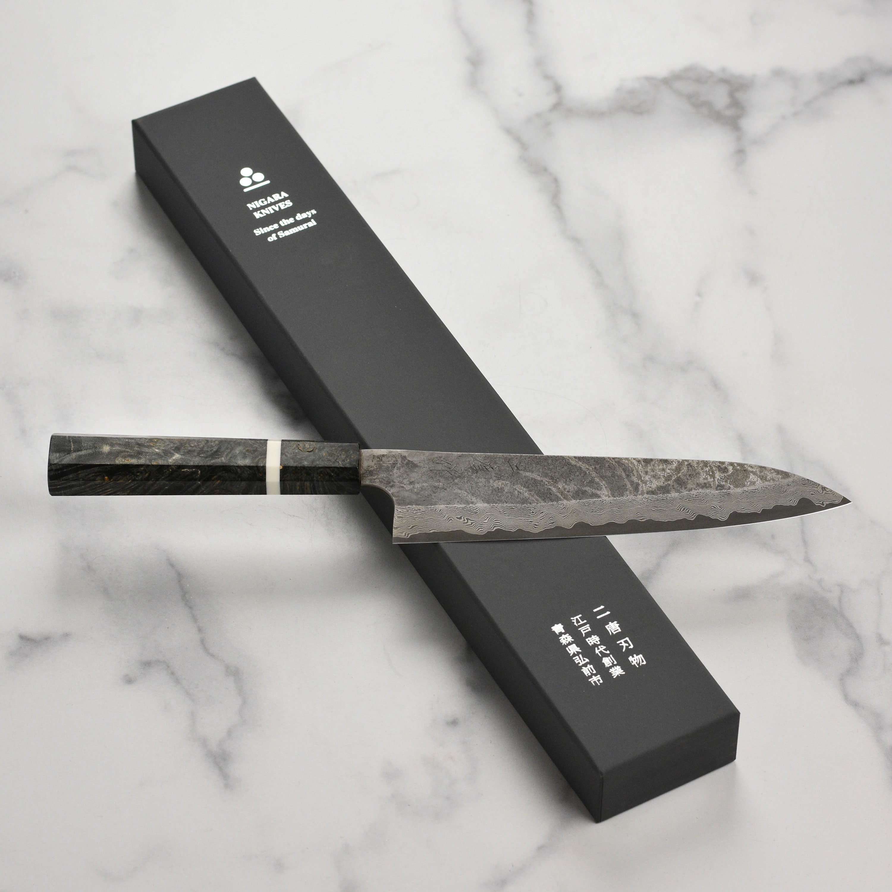 Close-up of Nigara Damascus gyuto knife blade highlighting Damascus steel pattern