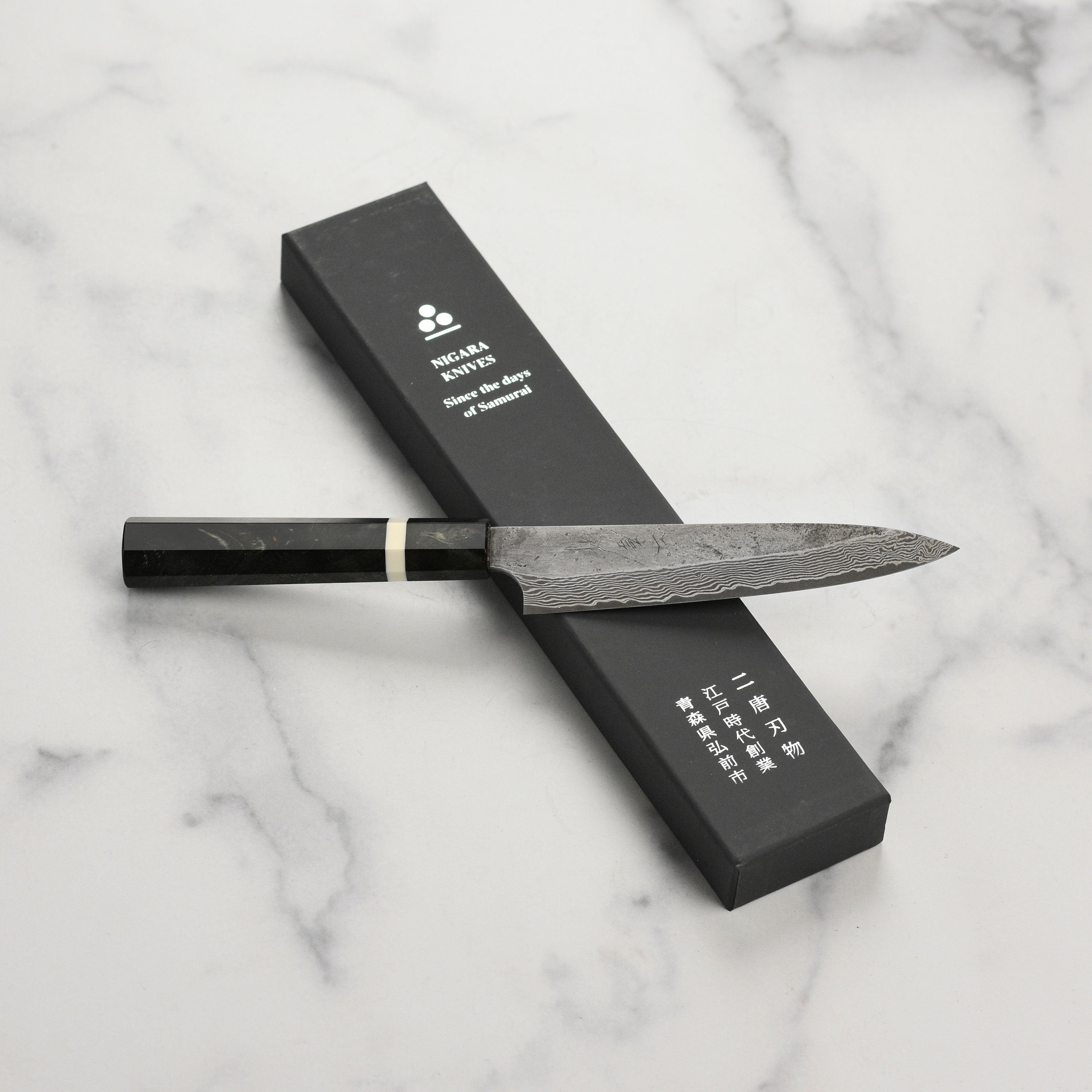Close-up of the Premium Nigara Ginsan Damascus Petty Knife showcasing its sharp blade and ergonomic handle.