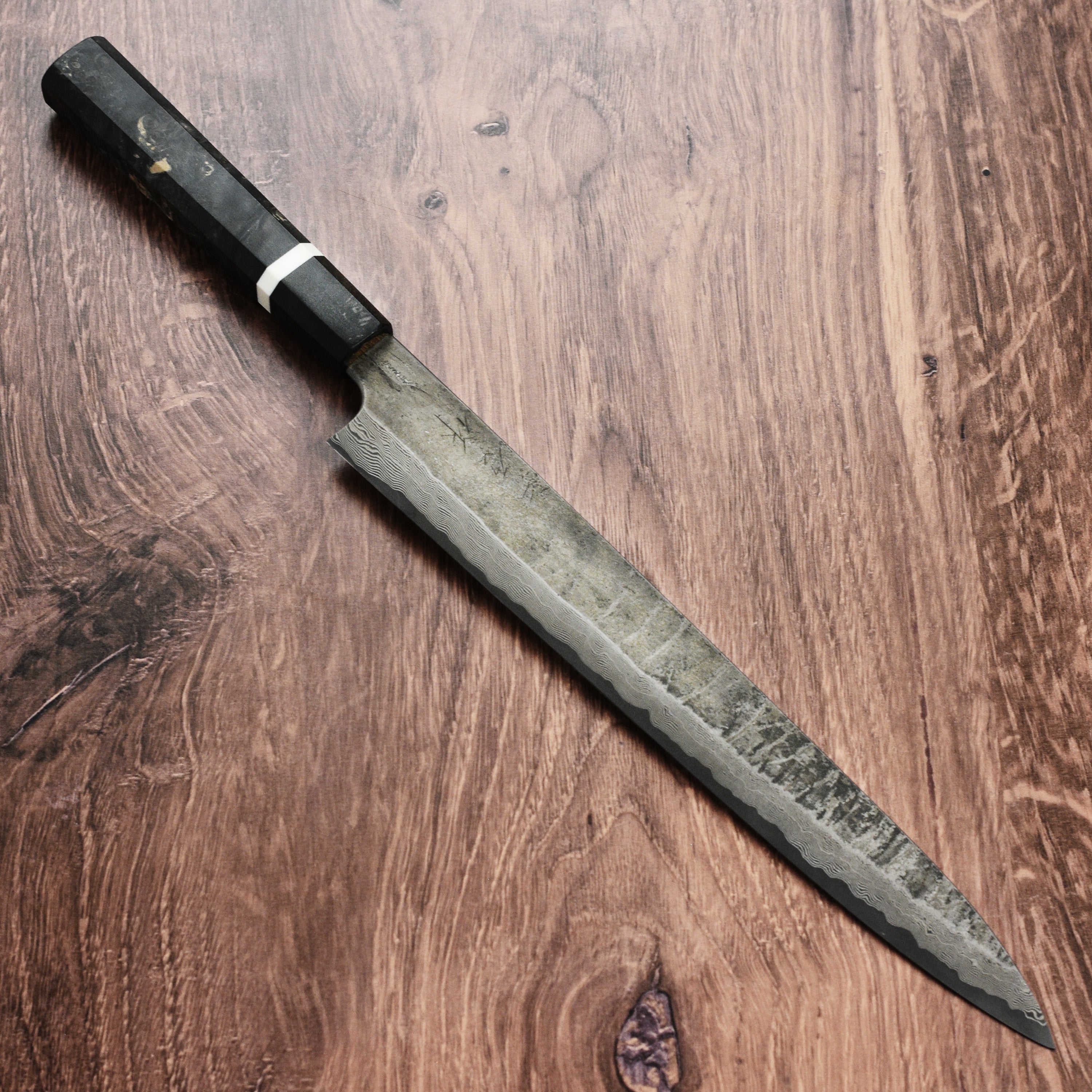 Chef using the Nigara Ginsan Damascus Sujihiki Knife to slice fish with precision.