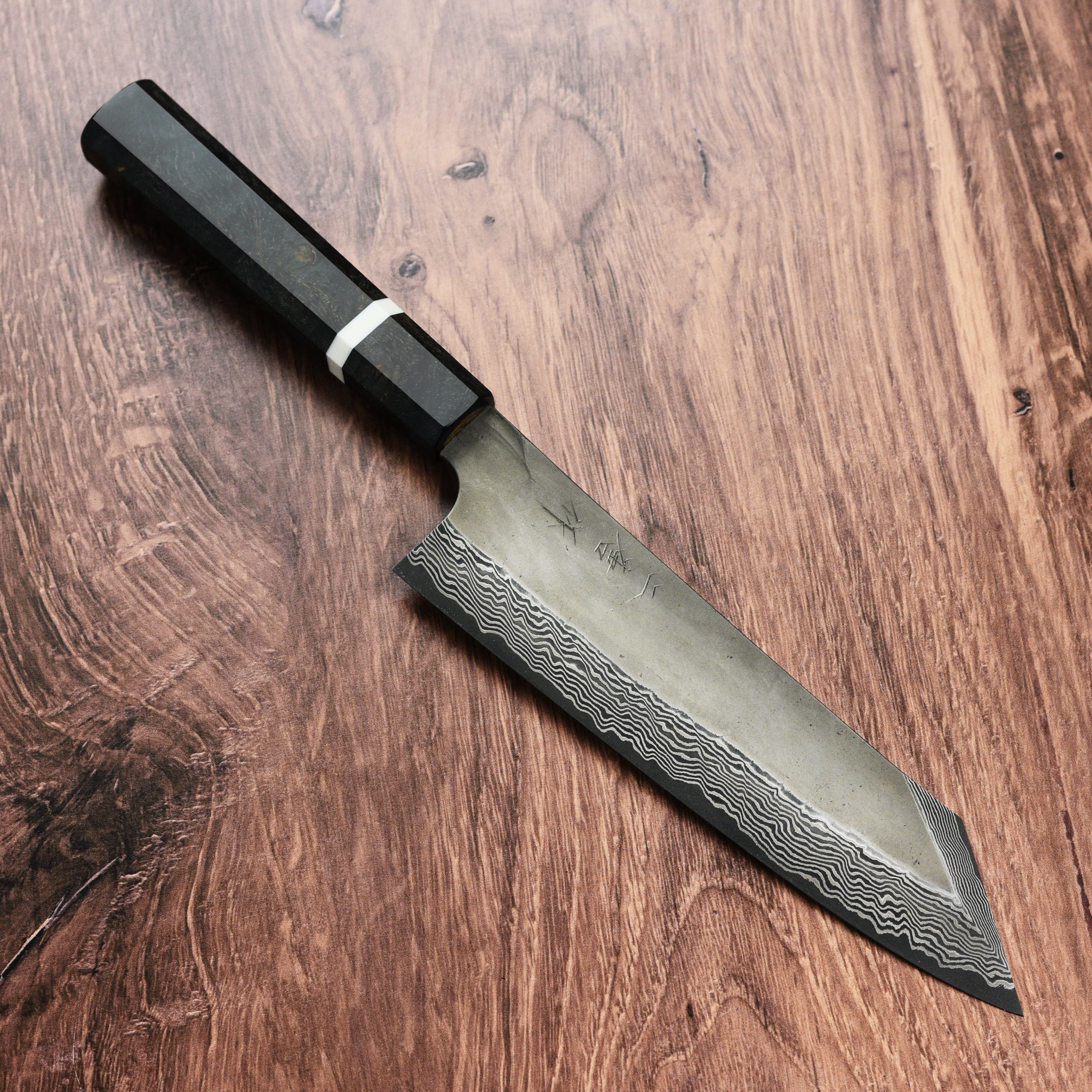 Chef slicing vegetables with a Nigara Ginsan damascus kitchen knife in a professional kitchen setting