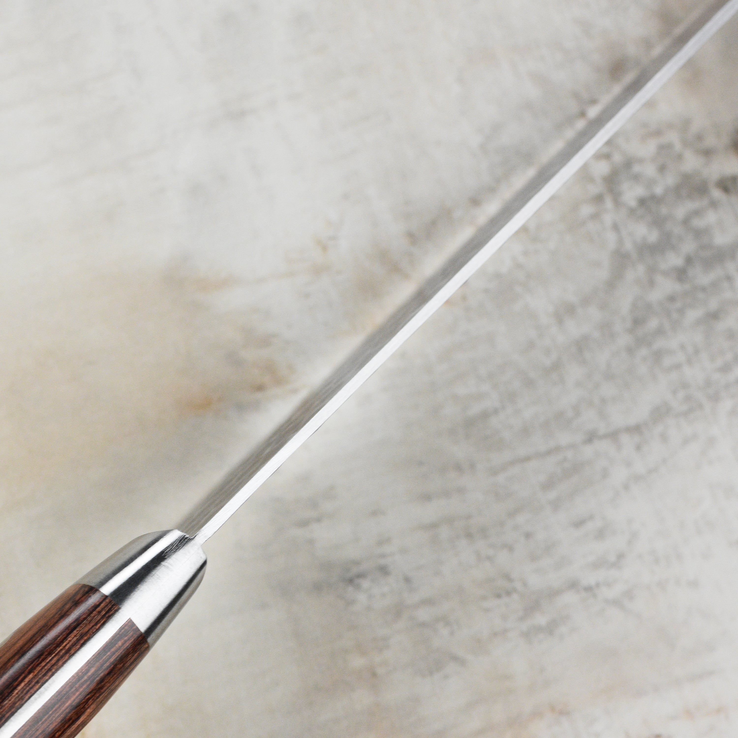 Ittetsu VG10 Premium Hammered Damascus Santoku Knife displayed on a wooden cutting board, highlighting its beautiful design.