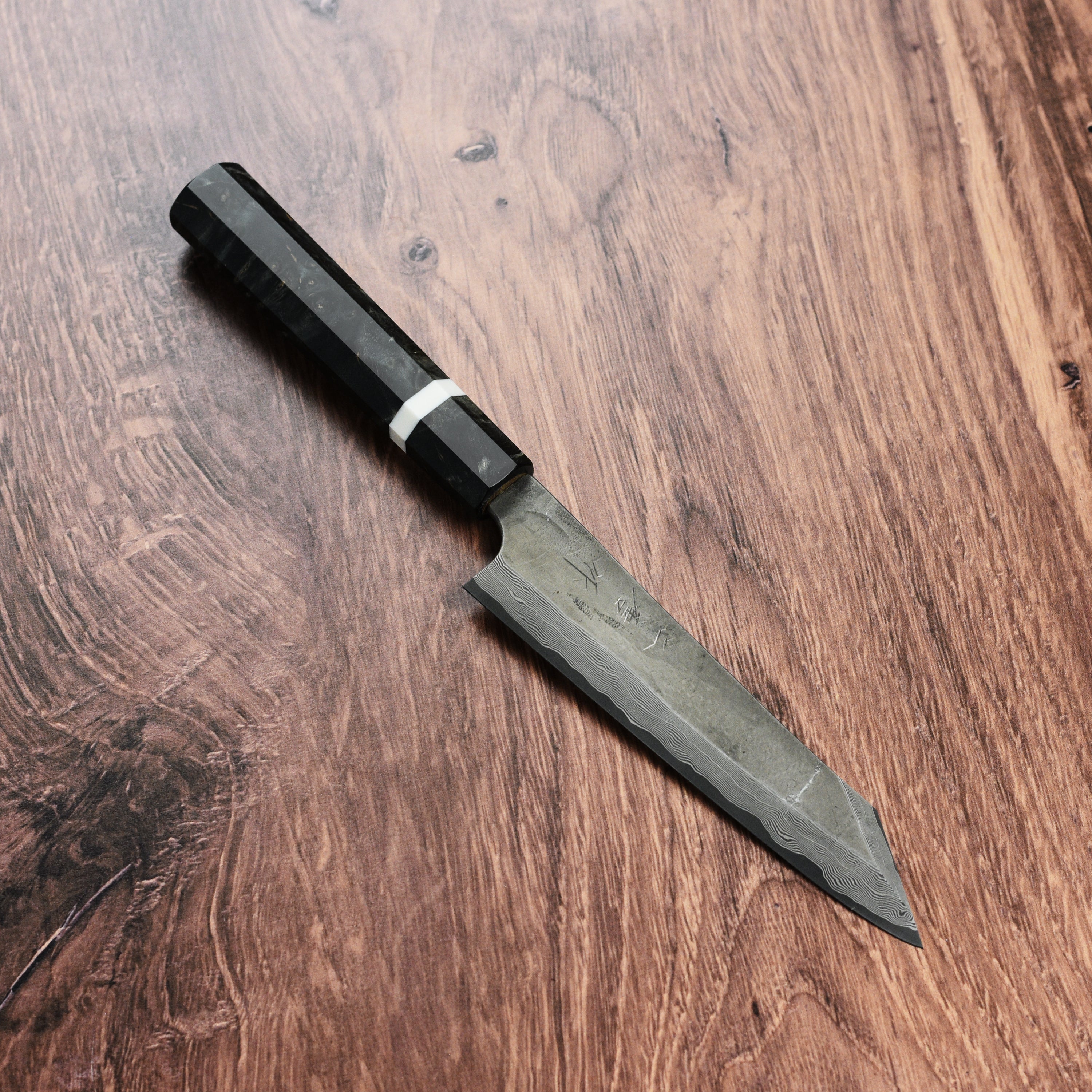 Professional chef using a damascus kiritsuke knife for vegetable prep
