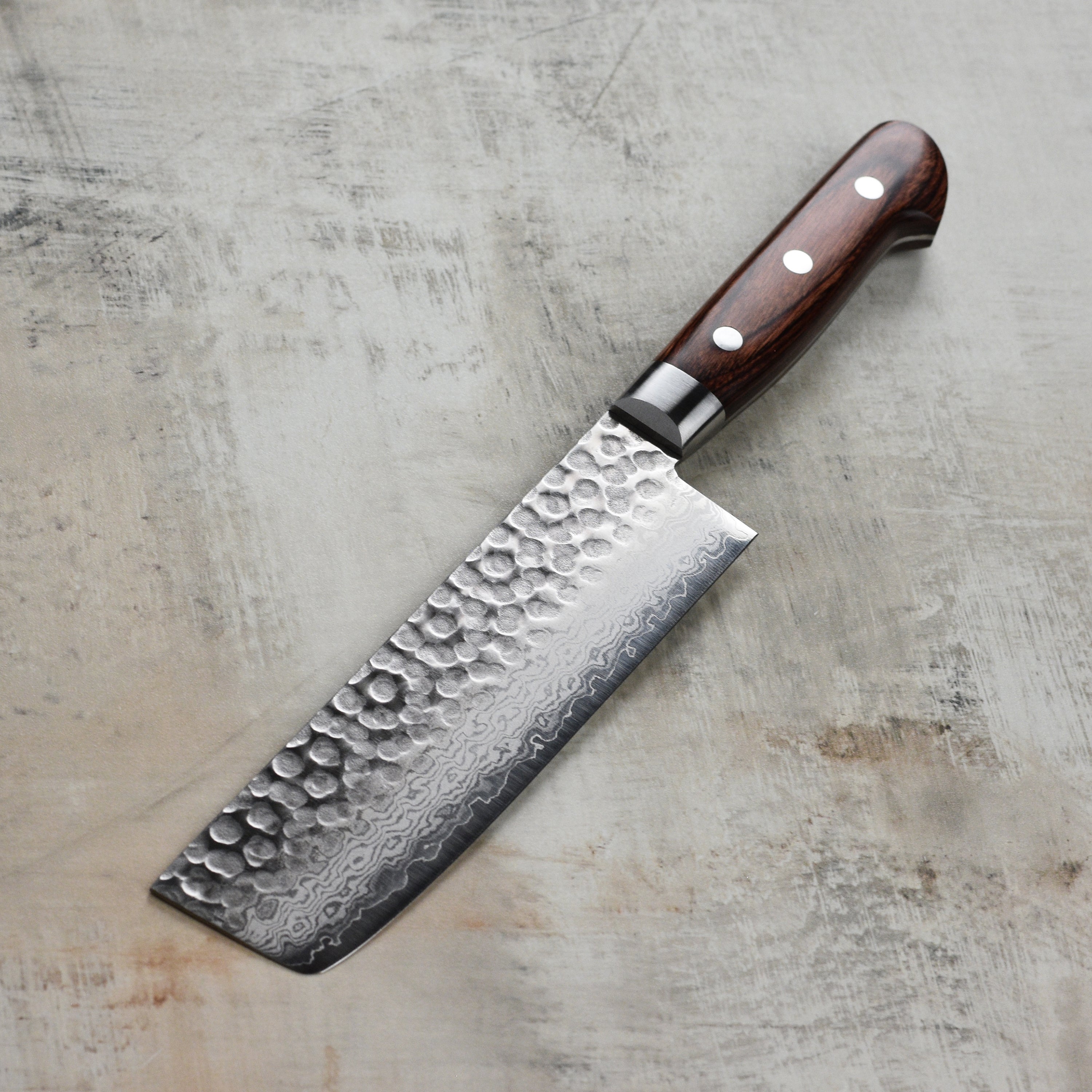The Ittetsu Nakiri Knife in action, slicing fresh vegetables on a wooden cutting board.