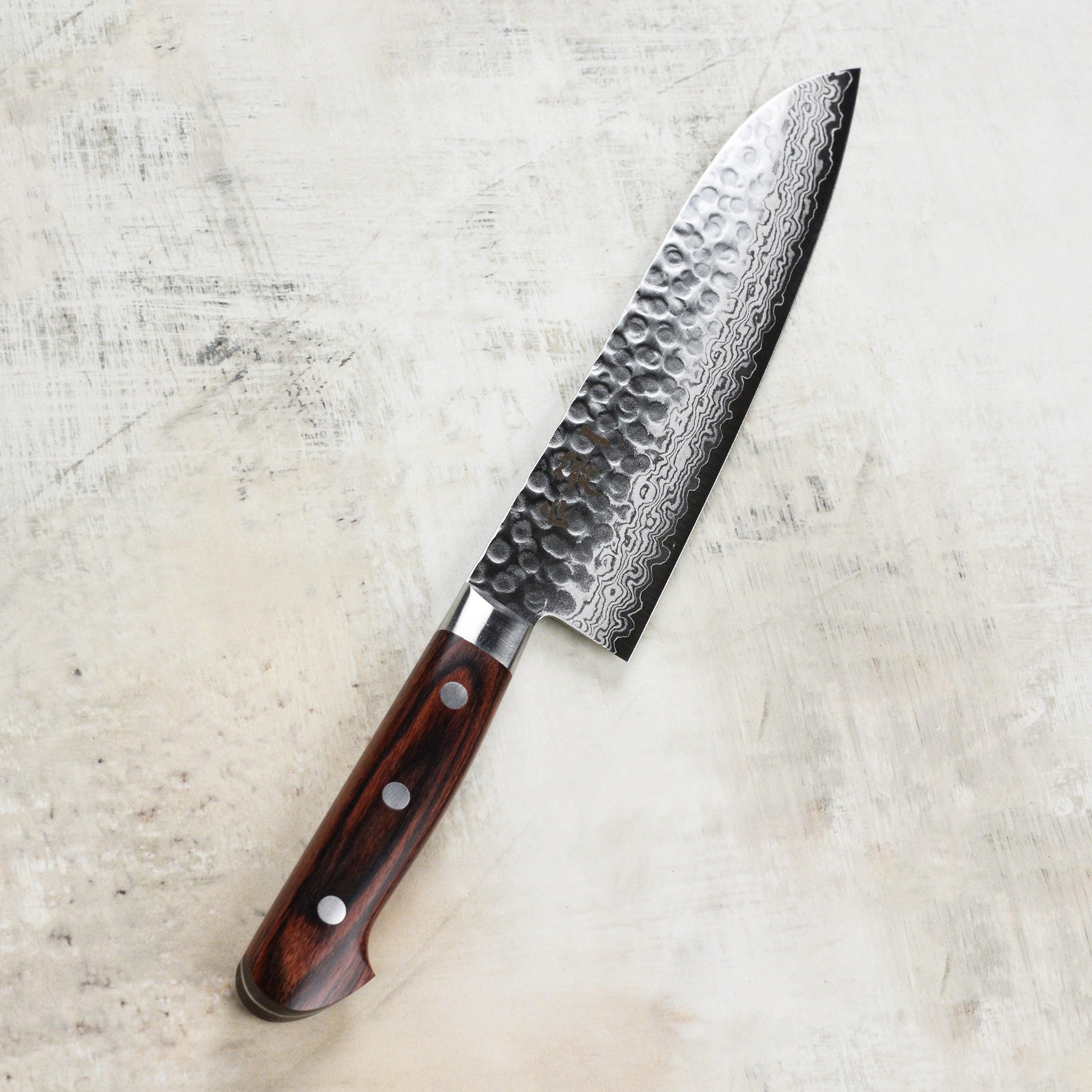 Close-up of the Ittetsu VG10 Santoku Knife in action, slicing fresh vegetables with precision.