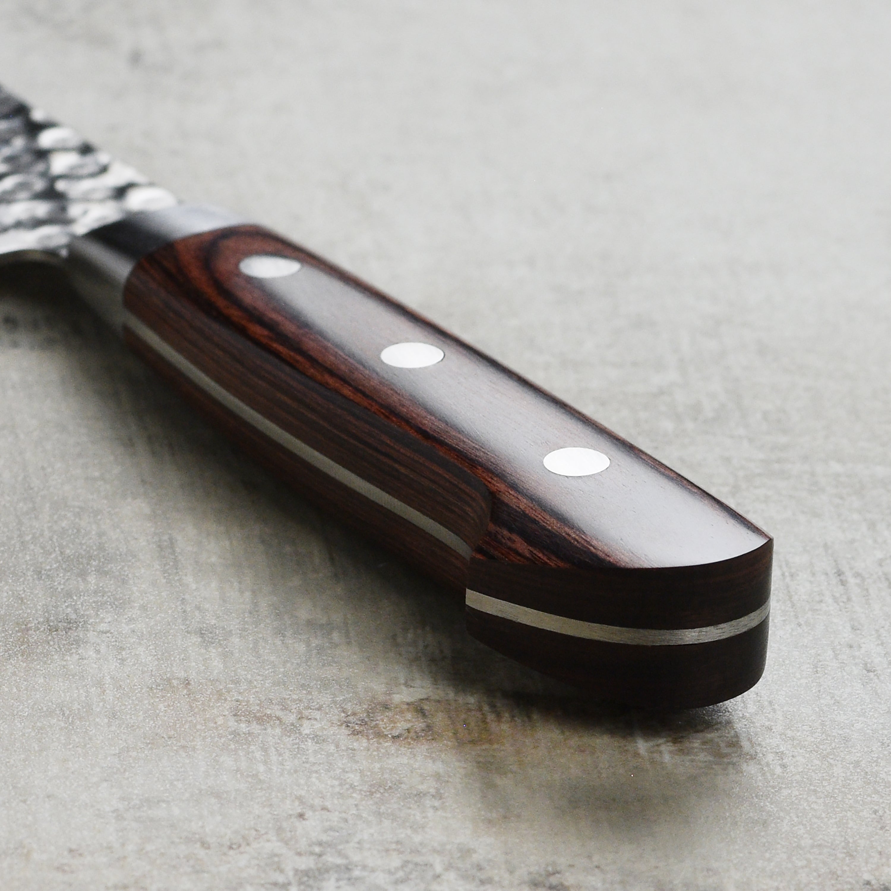 Close-up of the Ittetsu VG10 Santoku Knife in action, slicing fresh vegetables with precision.