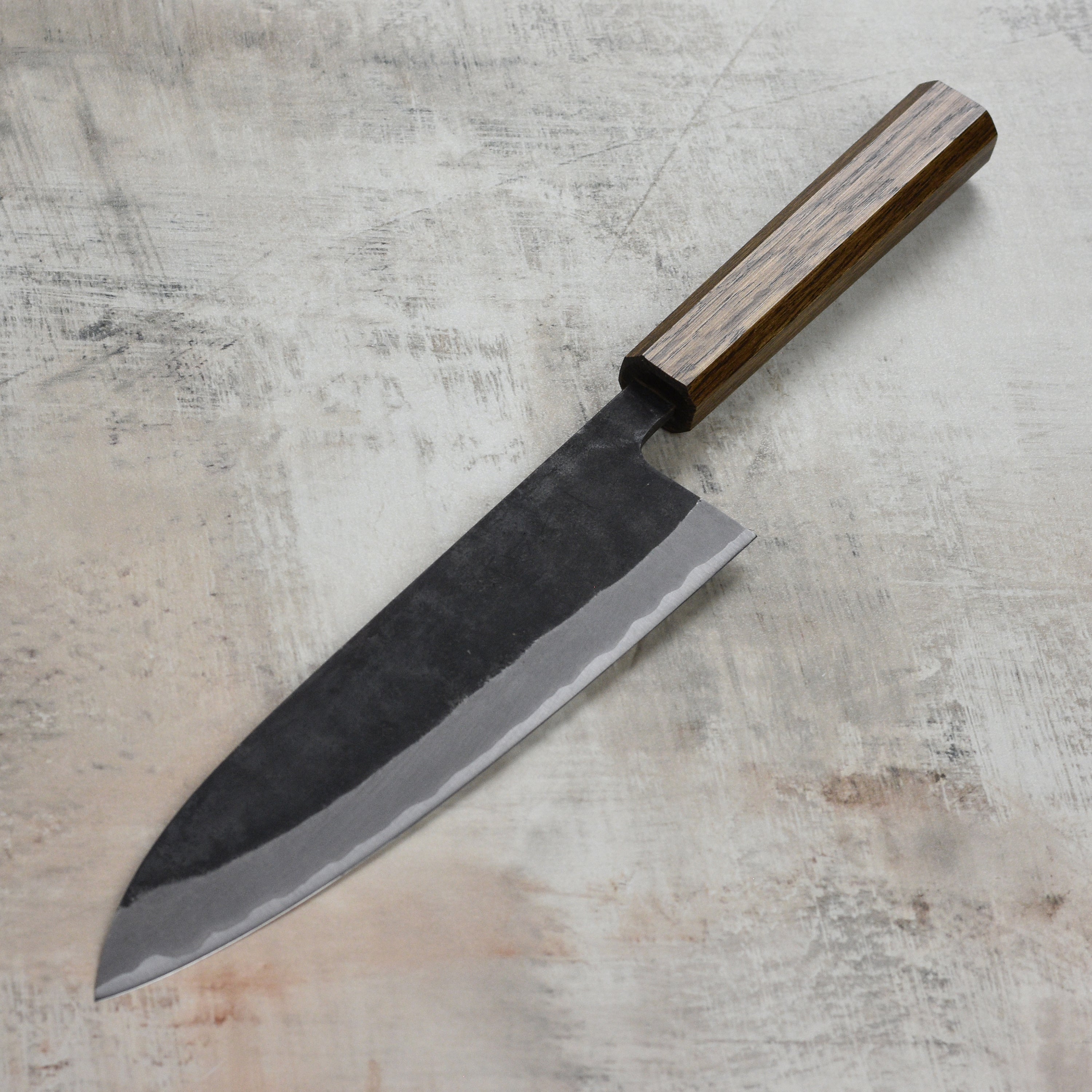 Close-up of the Shiro Kamo Aogami Super Gyuto's sharp stainless steel blade, highlighting craftsmanship