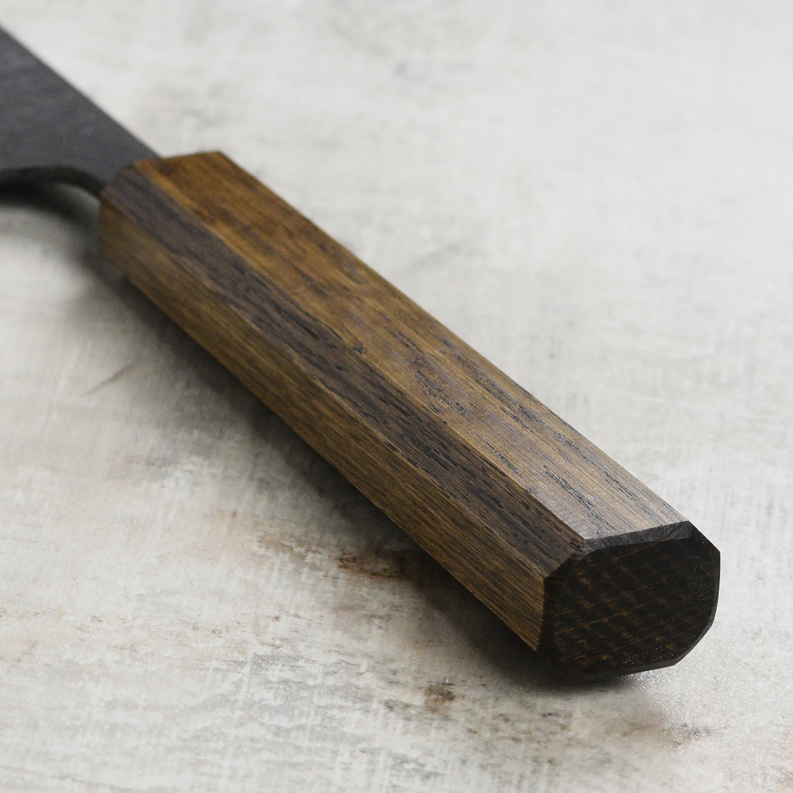 Chef slicing vegetables with the Japanese chef knife on a wooden cutting board