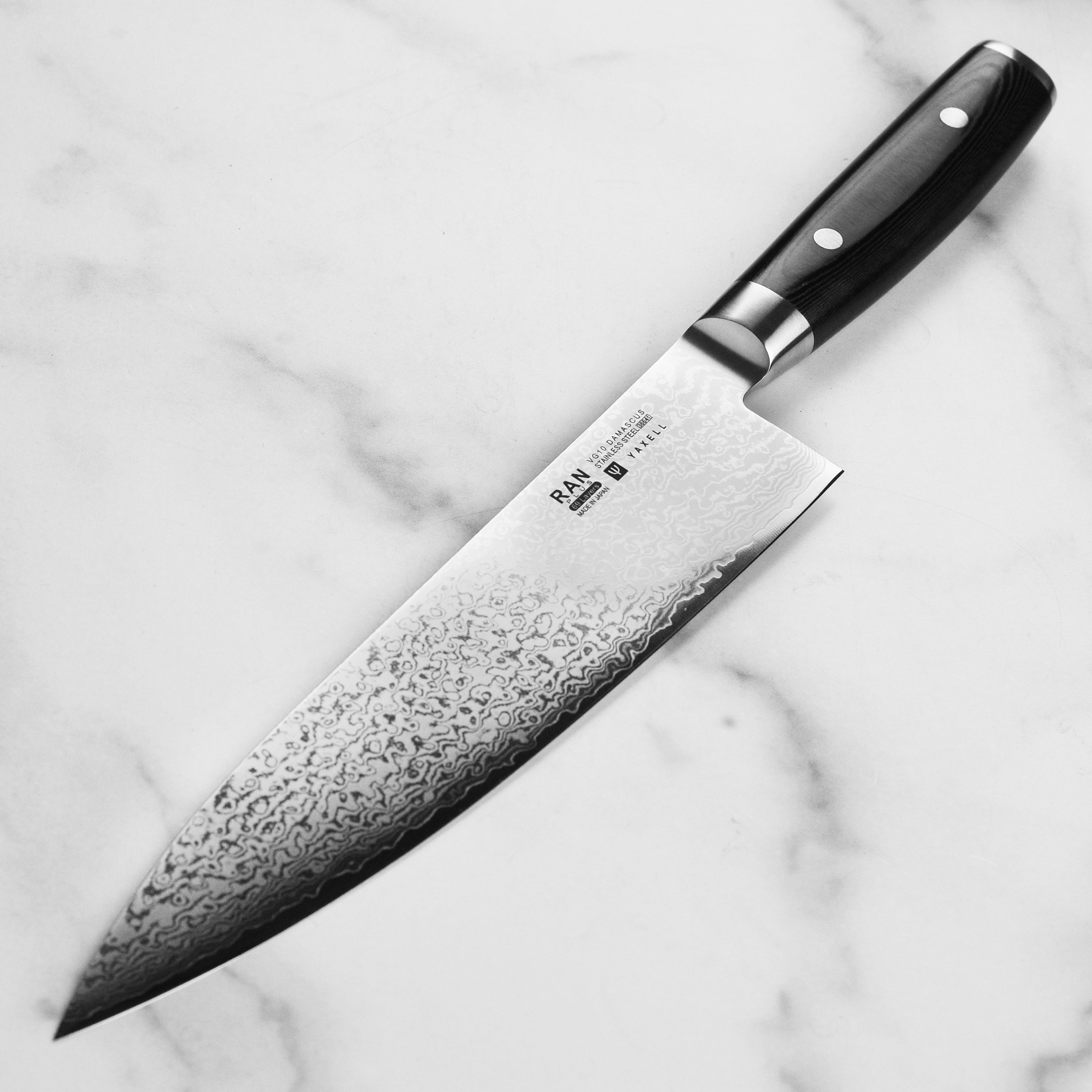 Yaxell Ran Plus 9.5" Damascus Knife in action, slicing through fresh vegetables.
