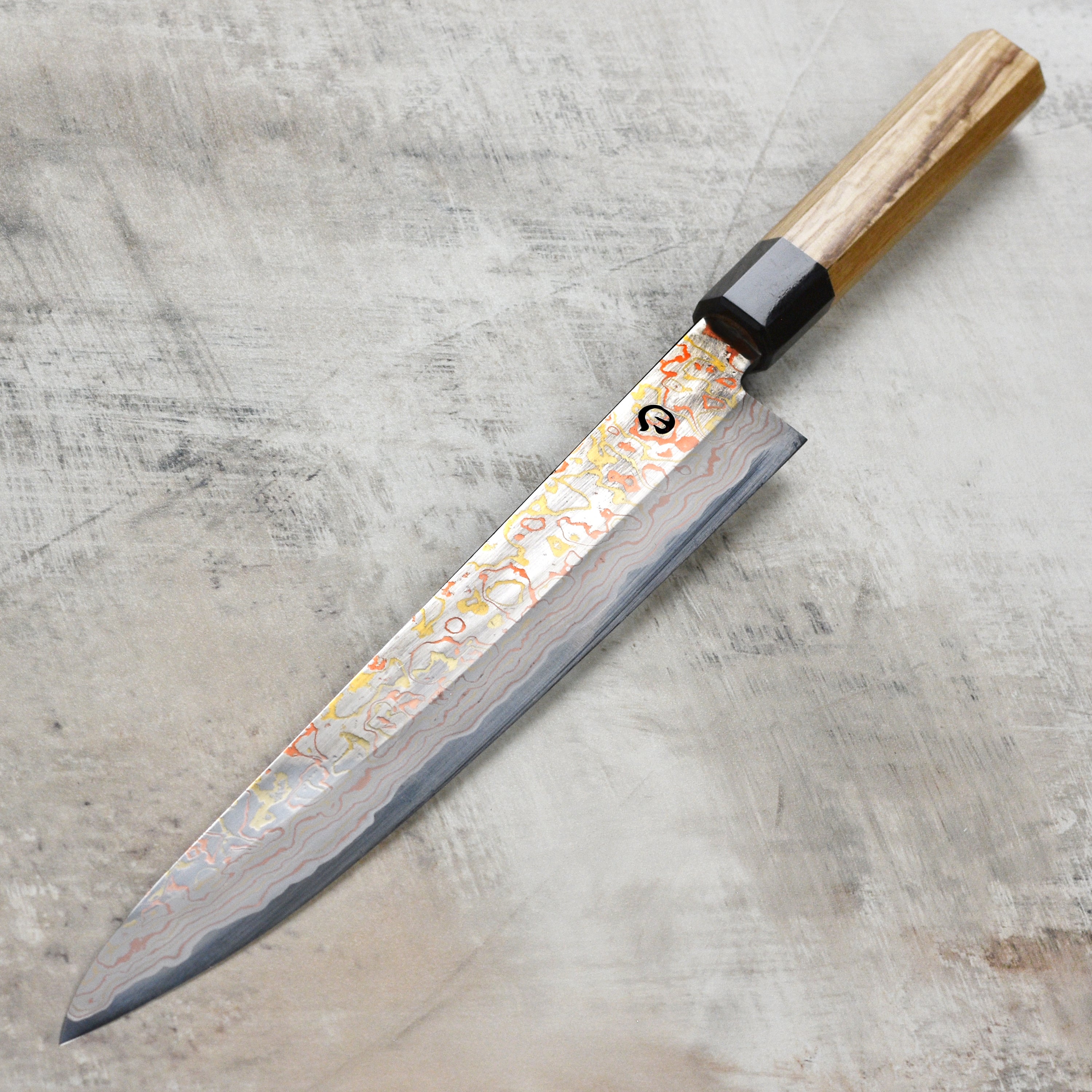 Close-up of Hinoura Damascus sujihiki blade showcasing intricate Damascus steel pattern