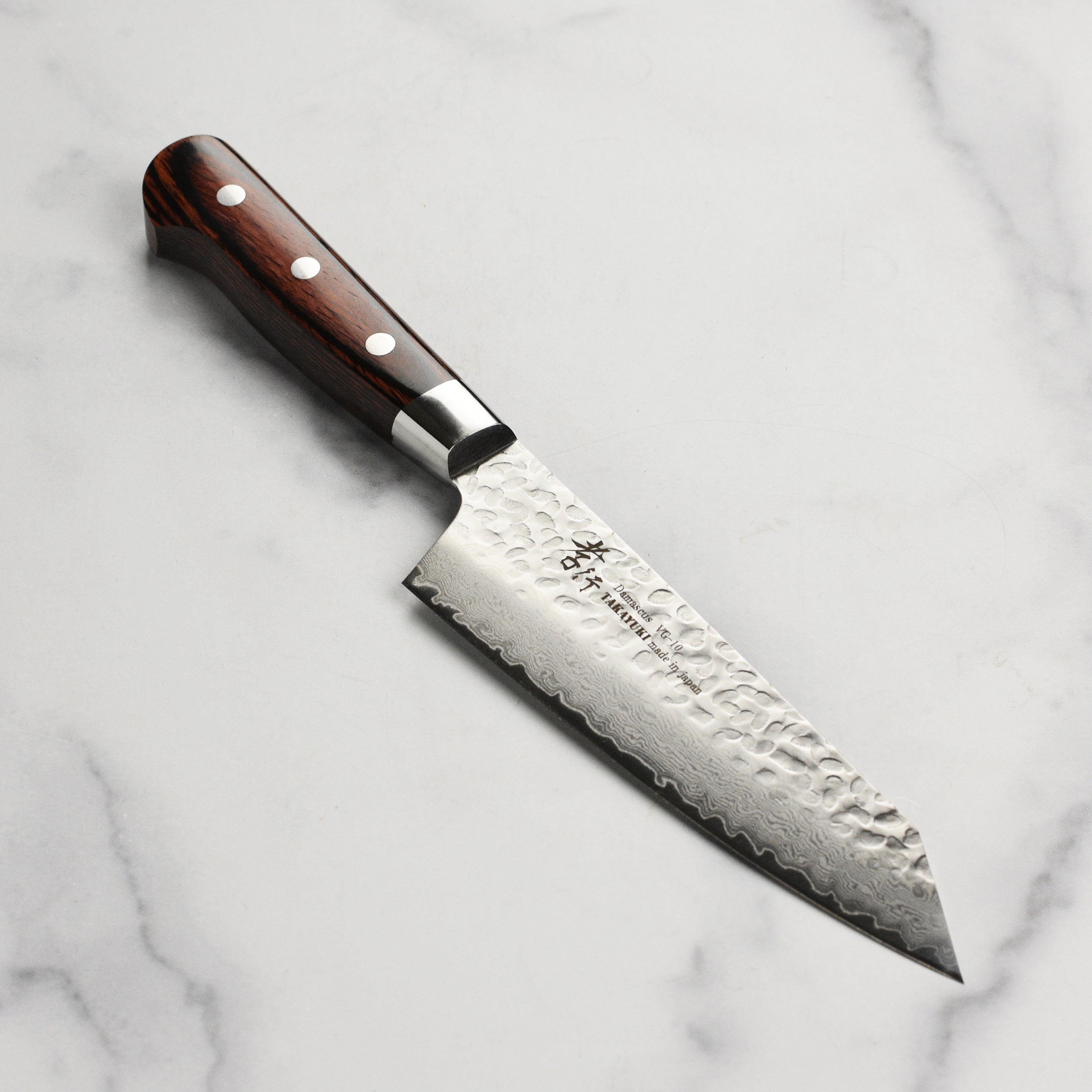 Takayuki Hammered Damascus Bunka Knife from the side, showcasing the blade's unique pattern.