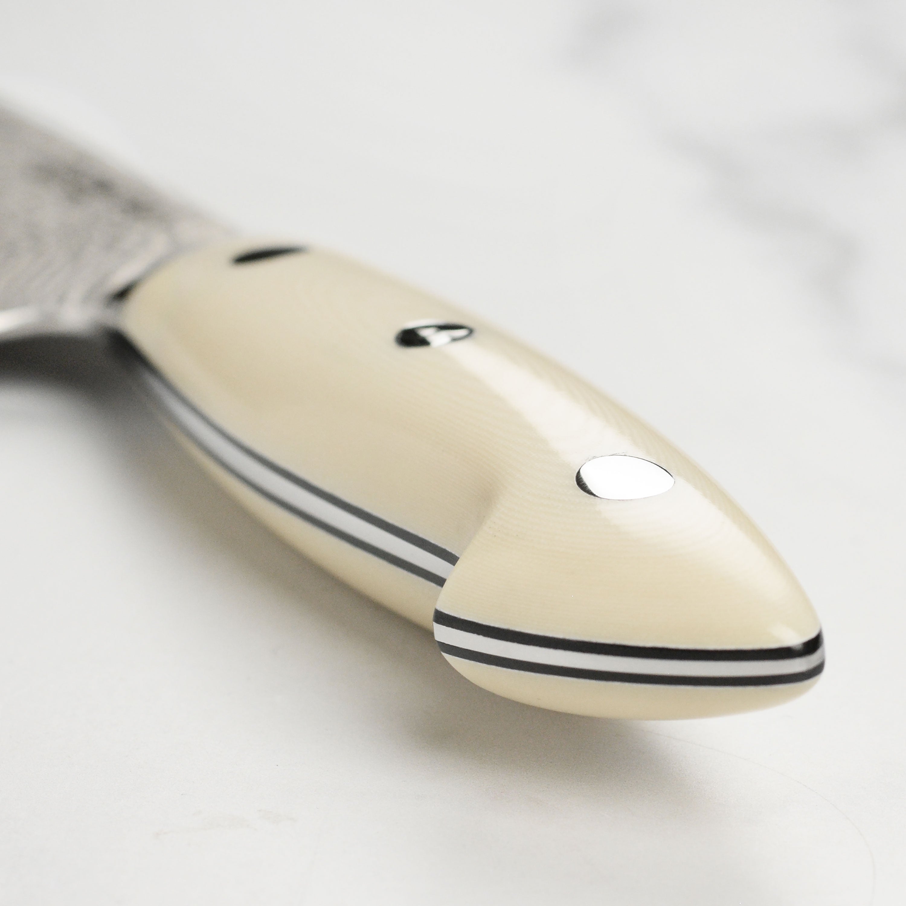 Close-up of the blade edge of the SG2 steel santoku knife, highlighting its sharpness and craftsmanship.