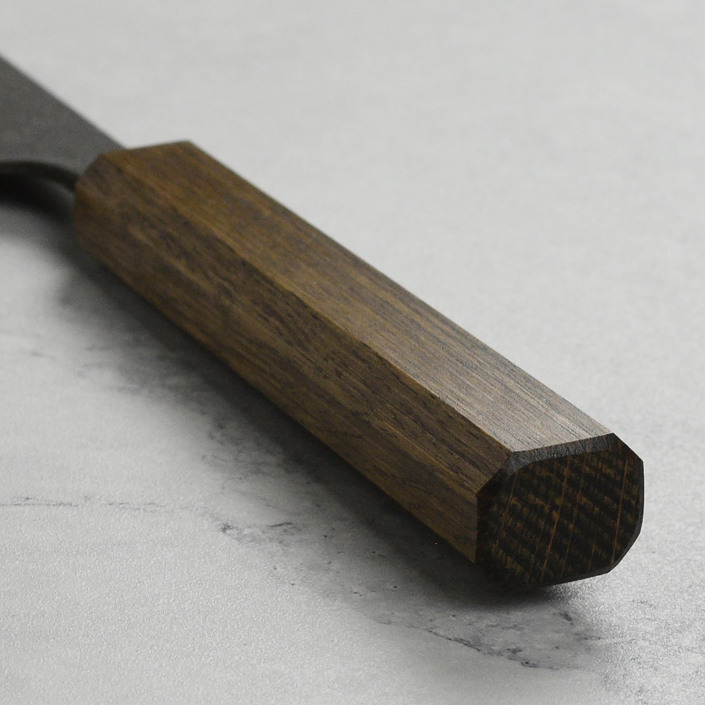 Shiro Kamo Aogami Bunka knife in action, slicing fresh vegetables on a wooden cutting board.