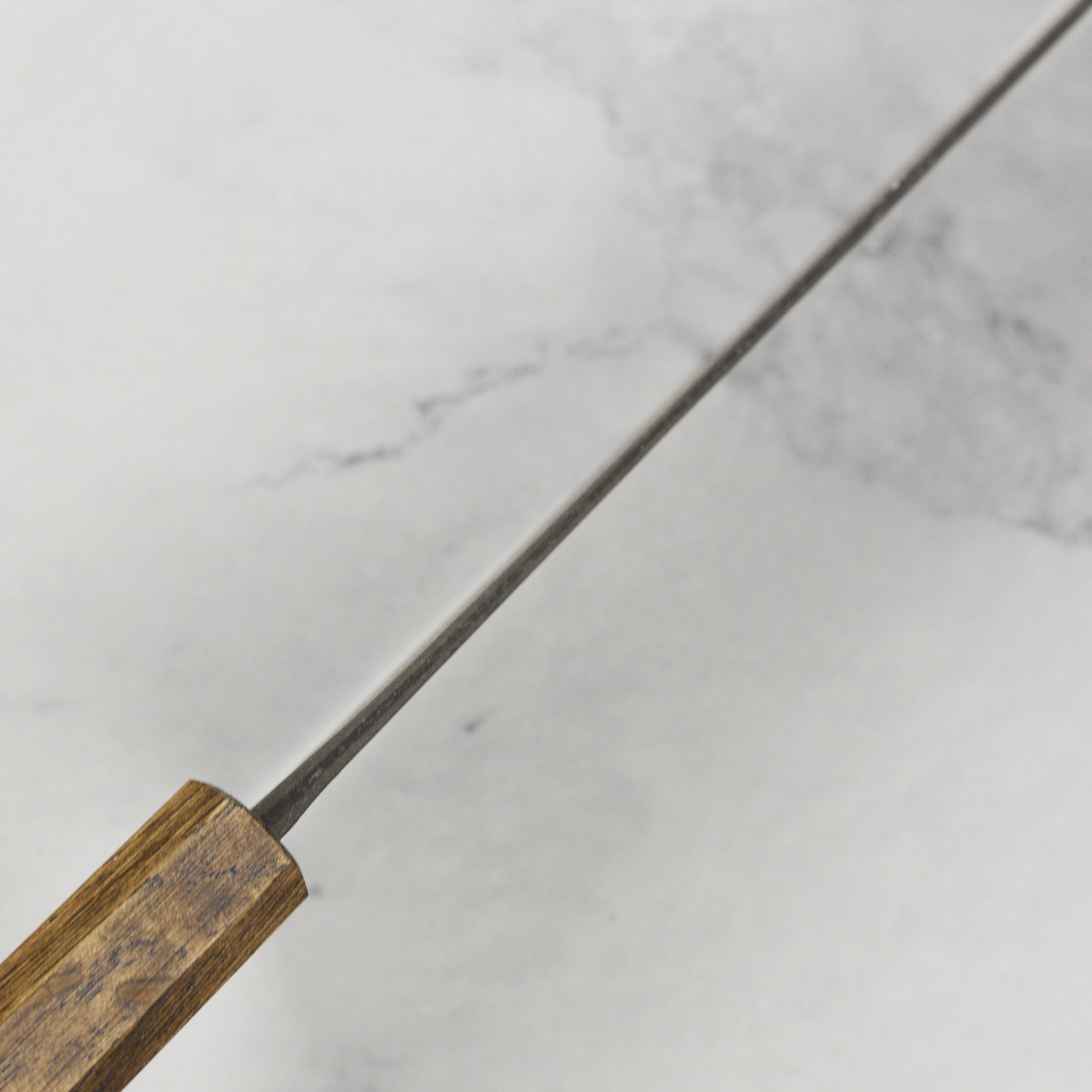 Elegant display of Shiro Kamo Aogami Bunka knife with its ergonomic handle and sleek design.