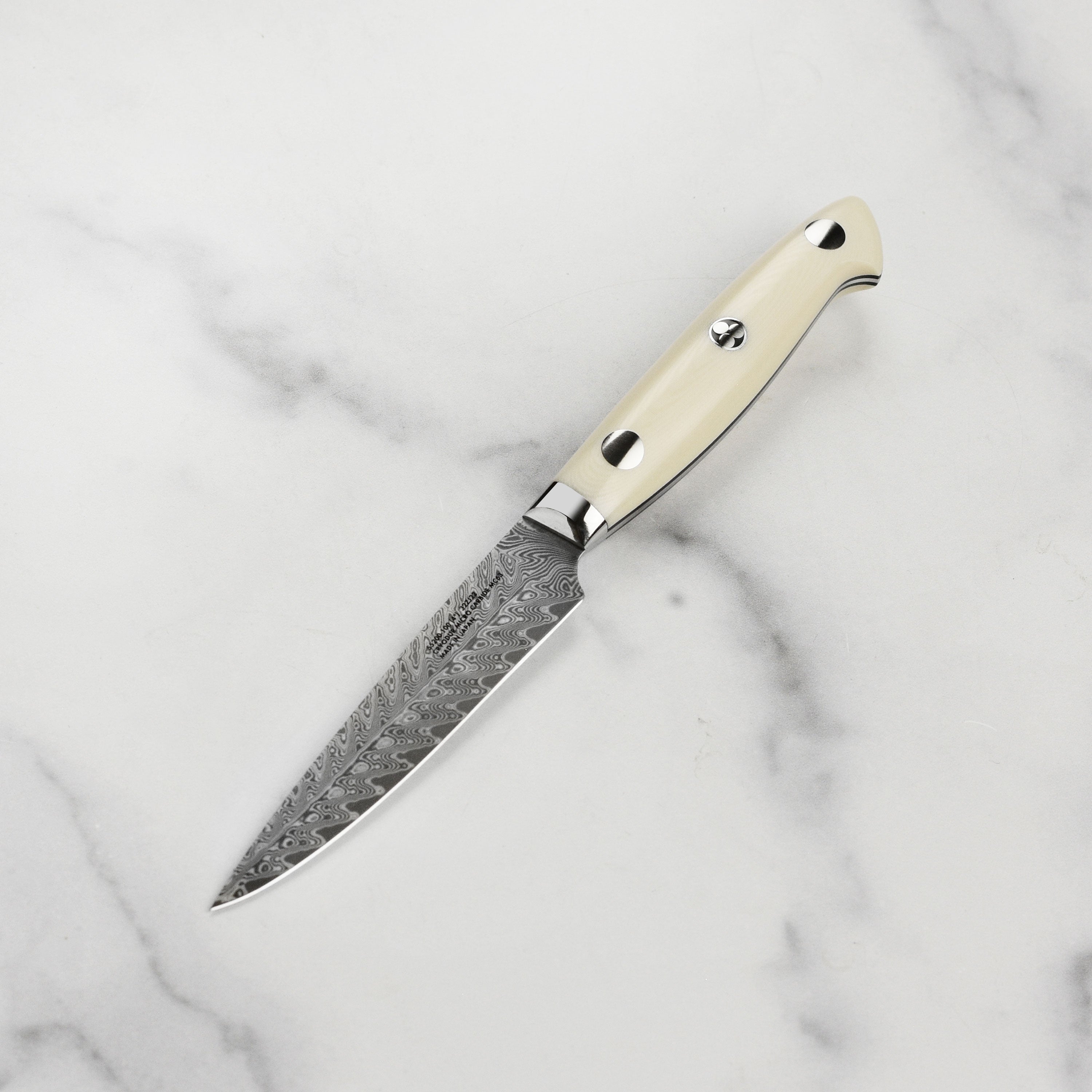 Japanese kitchen knife with intricate blade pattern and ergonomic handle