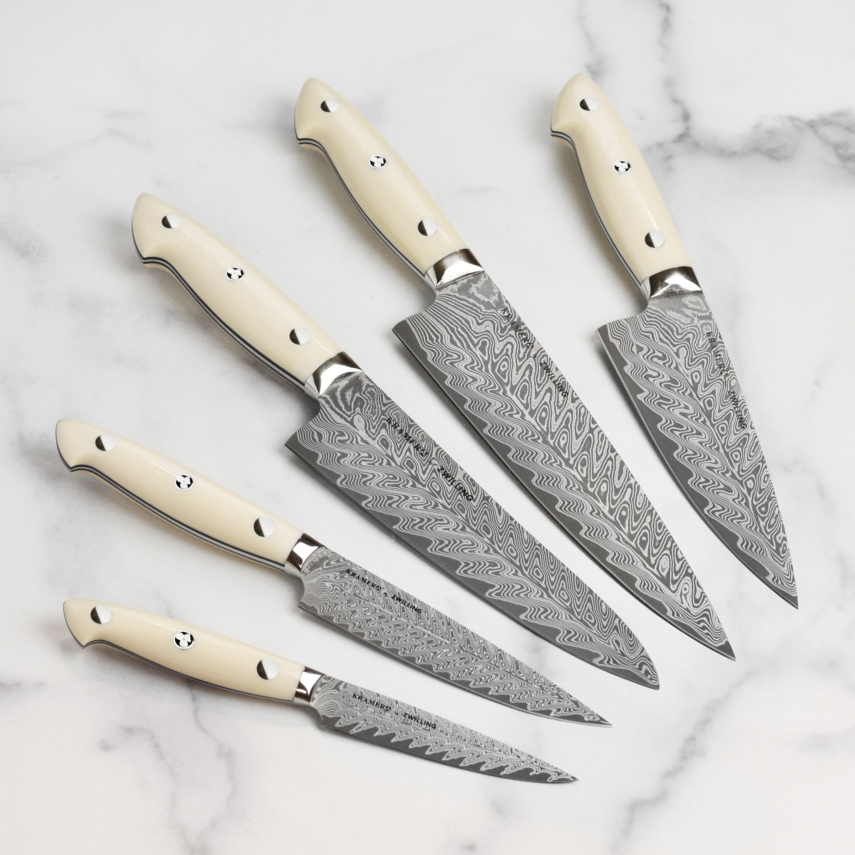 Chef using Kramer Cumulus knife for precision slicing in a modern kitchen