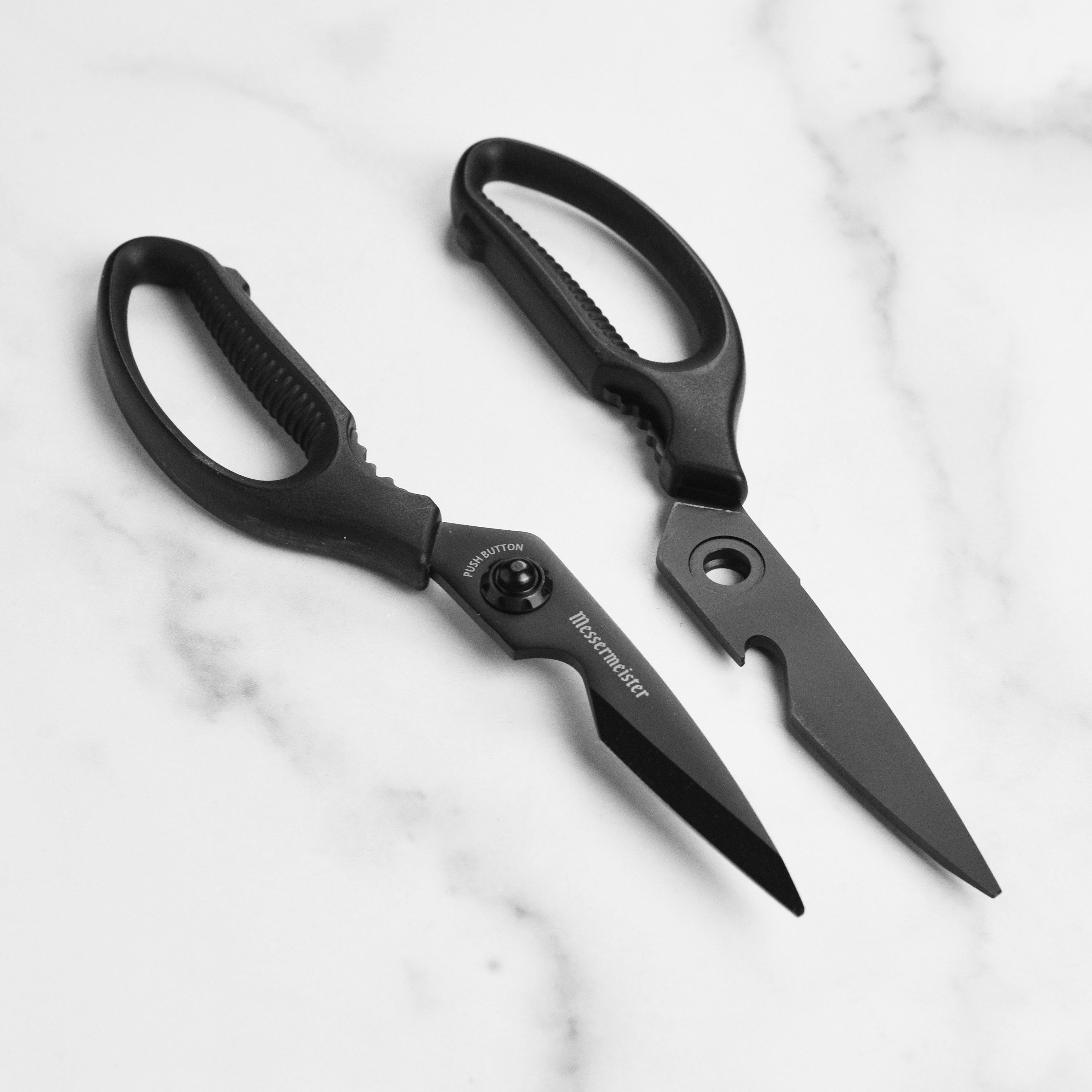 Close-up of titanium shears showing soft-grip handle and push-button blade release